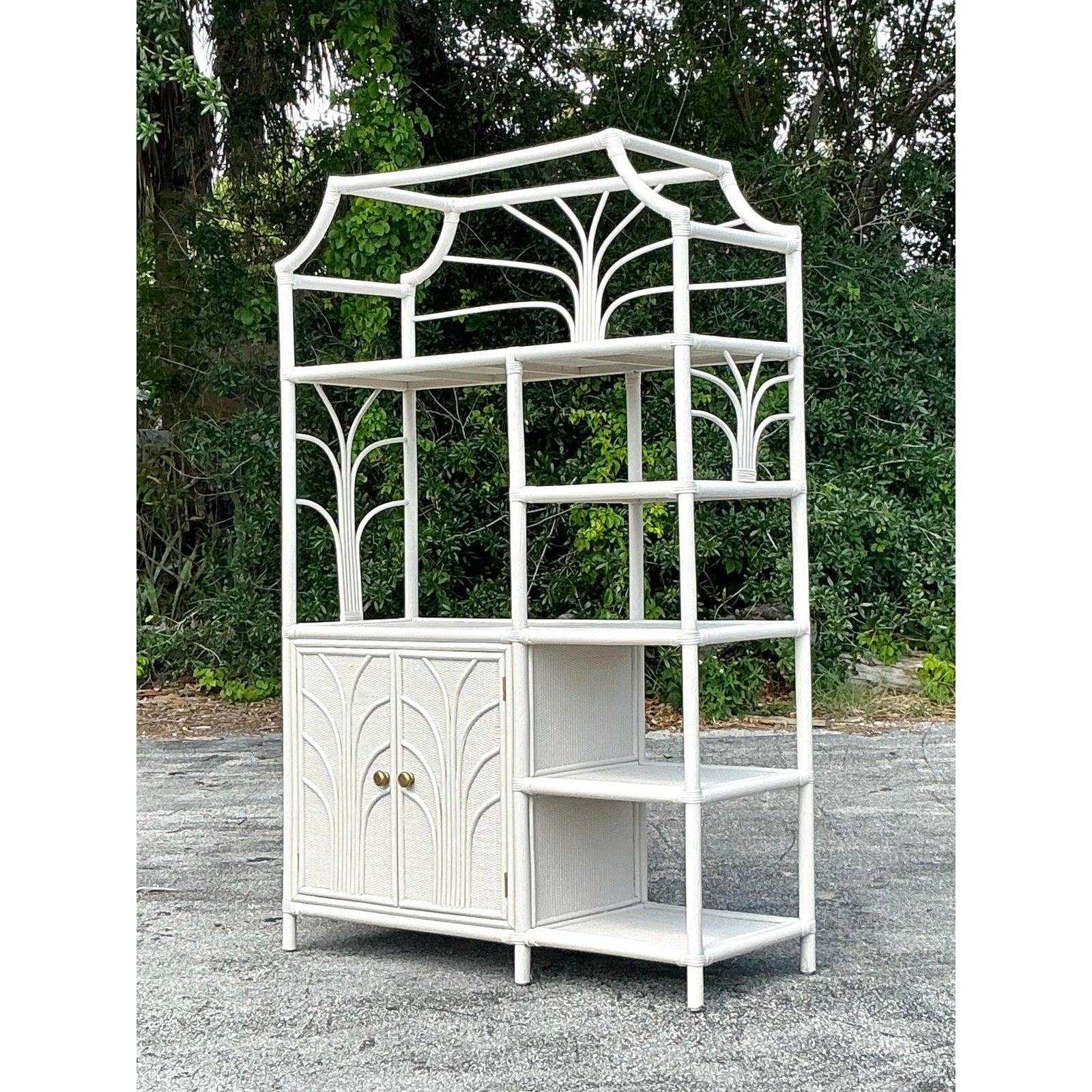Incanala il fascino della brezza e dello stile resort nel tuo spazio con questa Etagere in rattan dentellata Vintage Coastal. Caratterizzata da un piano in stile pagoda, pannelli intricati e dettagli ad arco sulle ante, questa scaffalatura d'effetto
