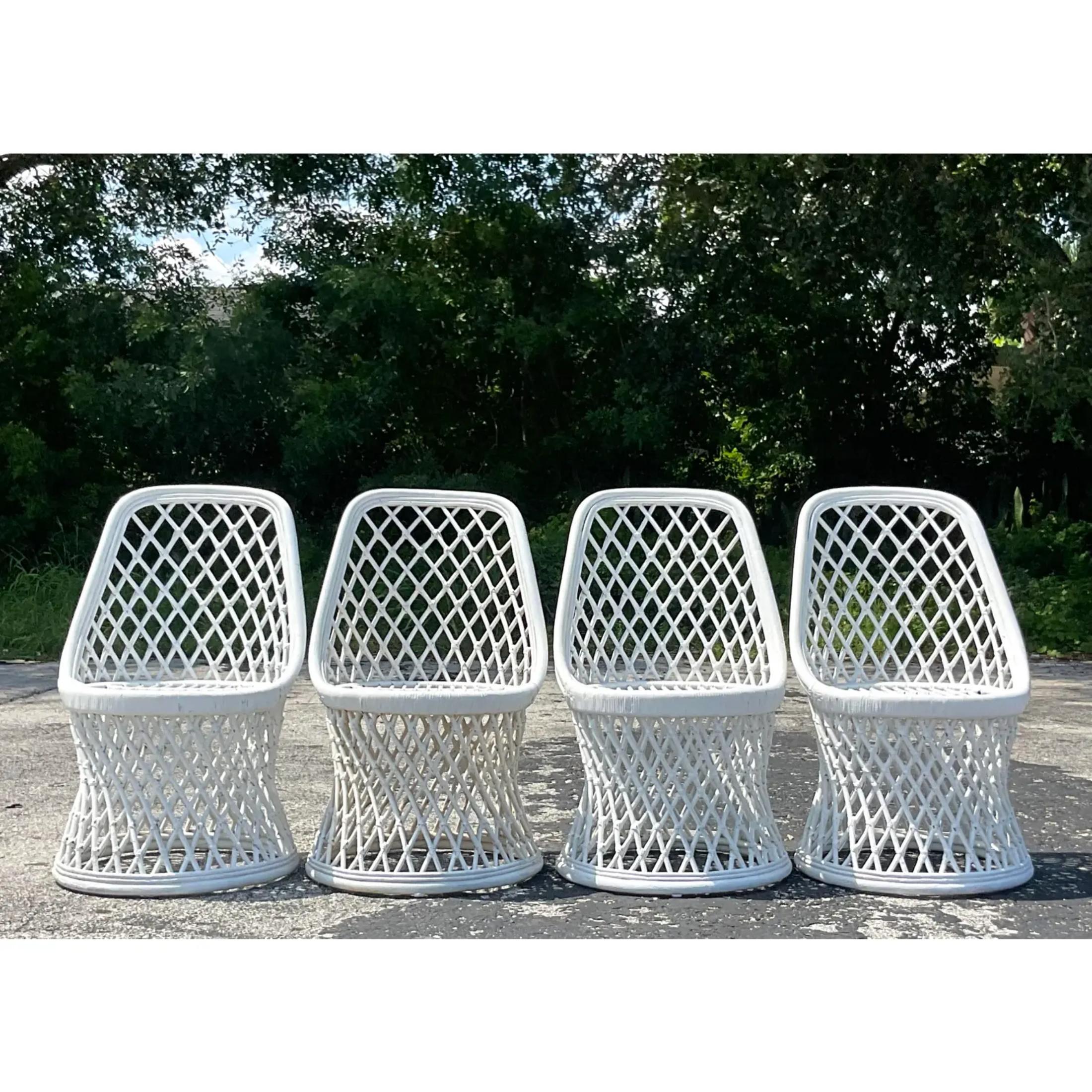A fabulous set of vintage Coastal dining chairs. Chic woven rattan in a trellis design. Acquired from a Palm Beach estate.