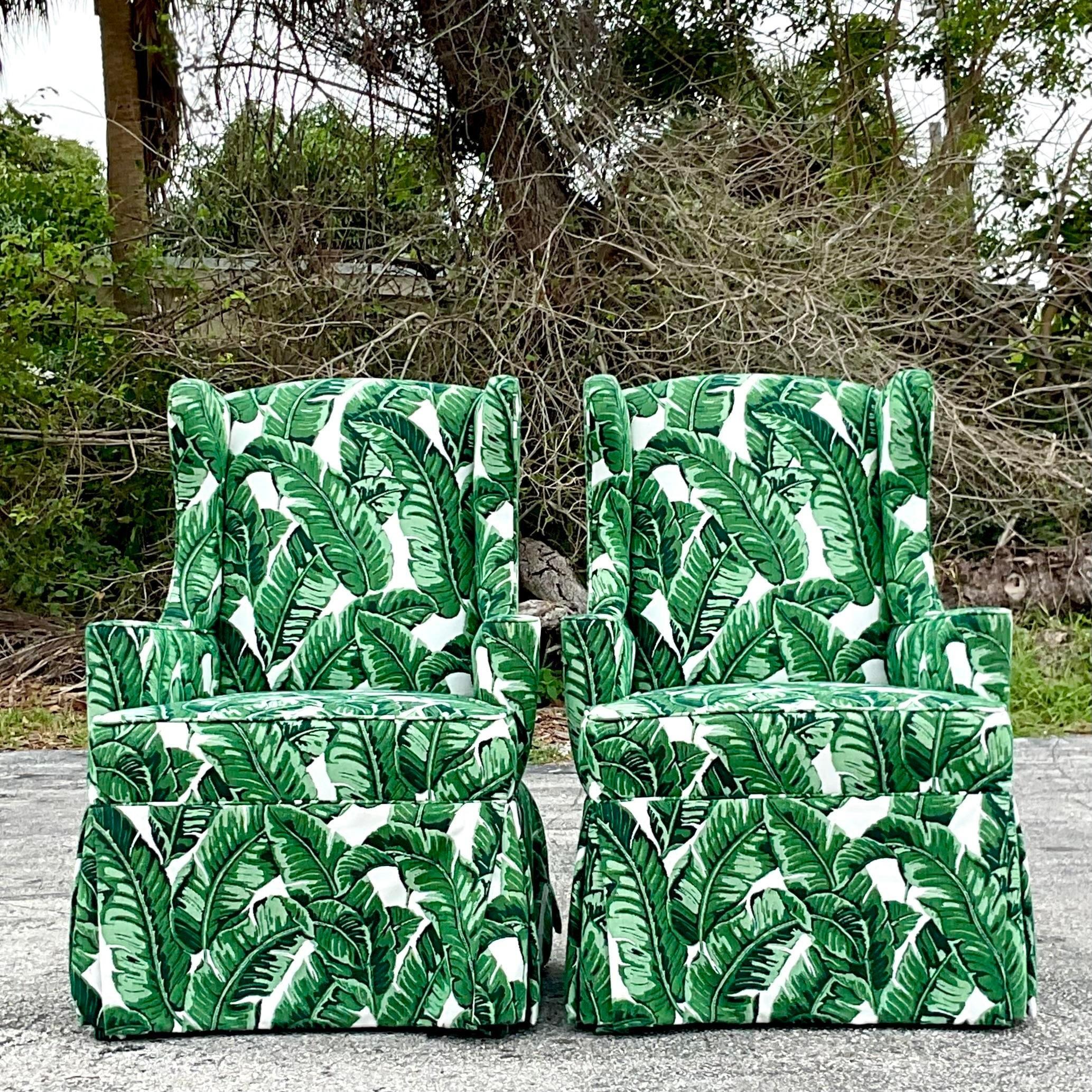 A fabulous pair of vintage Coastal wingback chairs. A chic modified scale with a clean and modern look. Upholstered in a fabulous palm front jacquard. Acquired from a Palm Beach estate. 