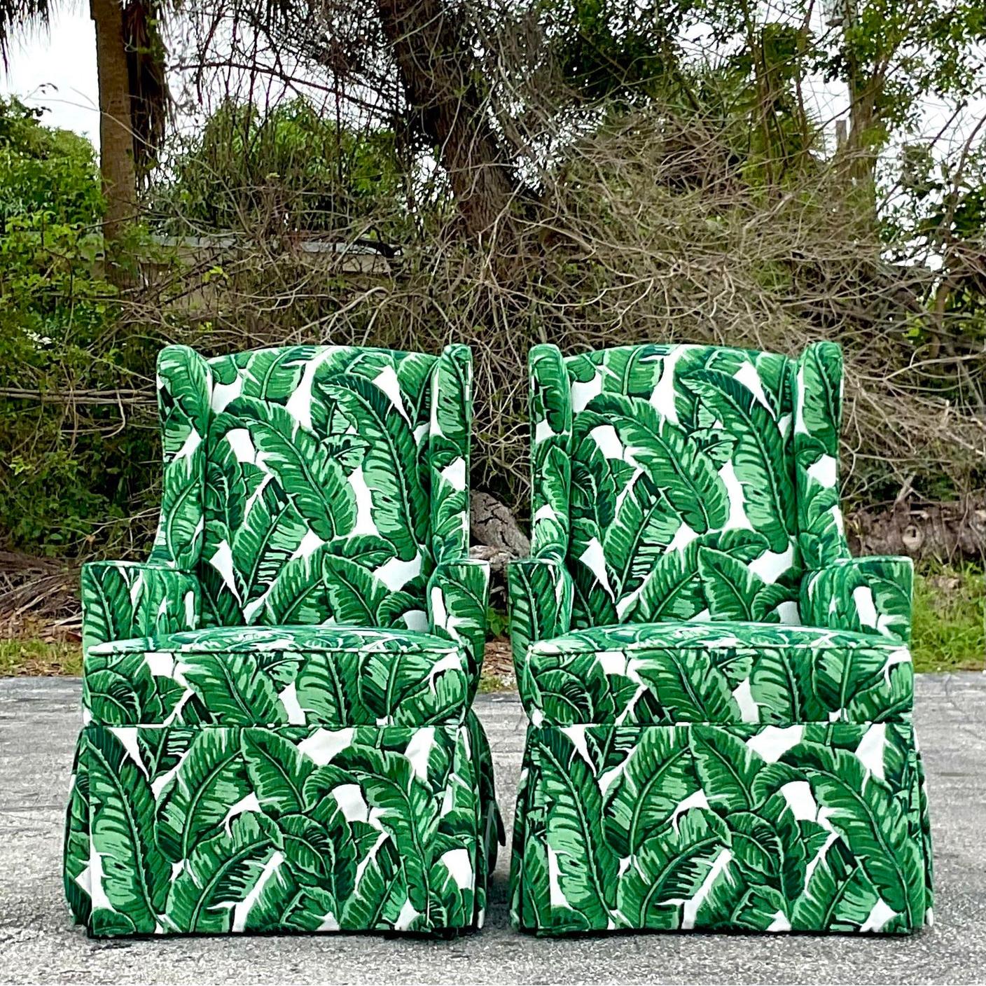 A fabulous pair of vintage Coastal wingback chairs. A chic modified scale with a clean and modern look. Upholstered in a fabulous palm front jacquard. Acquired from a Palm Beach estate. 