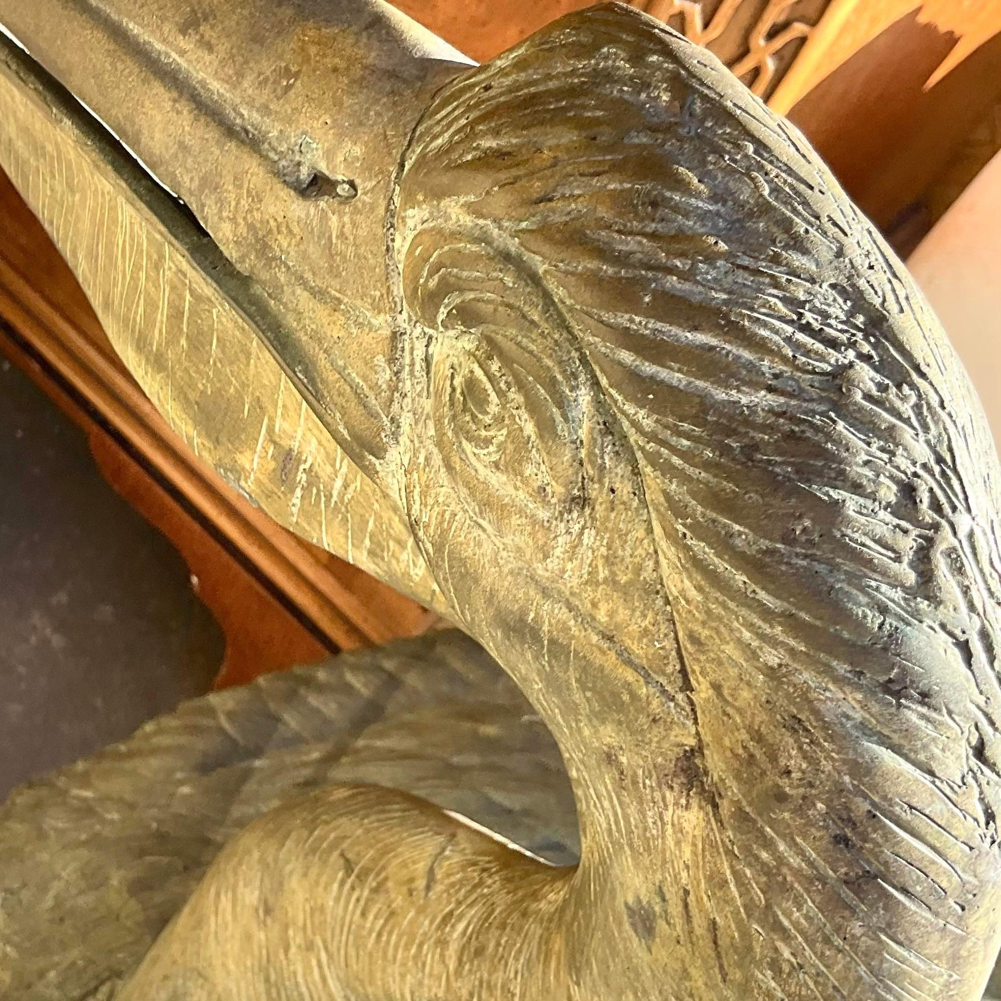 A stunning set of two vintage Coastal pelicans. Chic life size birds with incredible attention to detail. A beautiful all over patina from time. Acquired from a Palm Beach estate.

Lower pelican 20.5x9.5x23.5