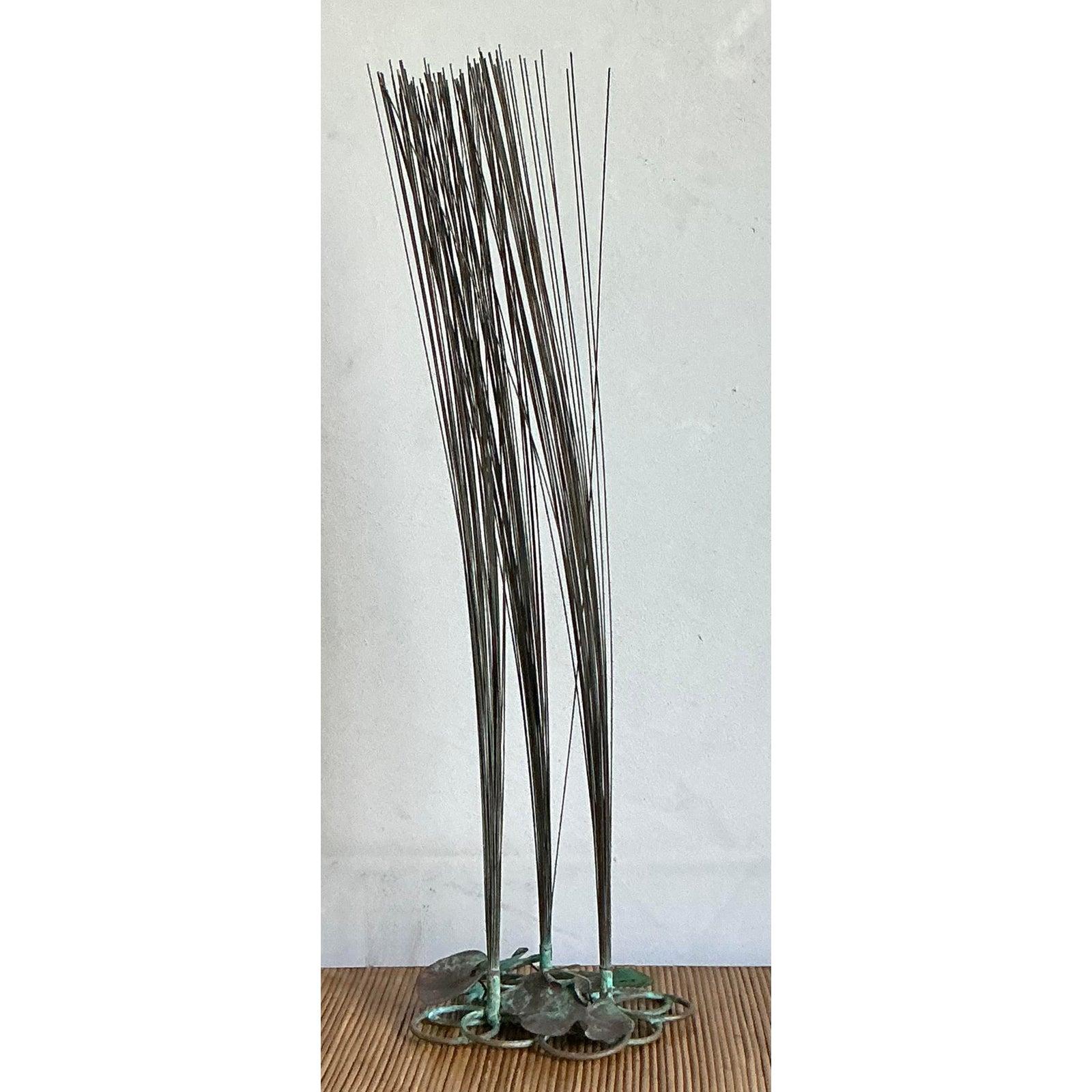 Cattura la tranquilla eleganza di una palude spazzata dal vento con questa splendida scultura vintage di erba alta. Esempio squisito di lavorazione artigianale del metallo, questo pezzo è caratterizzato da decine di sottili canne di metallo che