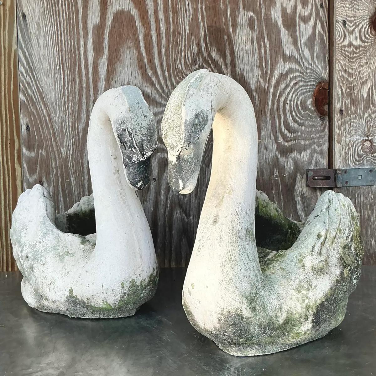 This stunning pair of vintage cast concrete swans brings a timeless coastal charm to any outdoor or indoor space. Each swan stands at an impressive 17.5 inches tall, with a graceful neck curve and finely detailed wings, offering a serene yet
