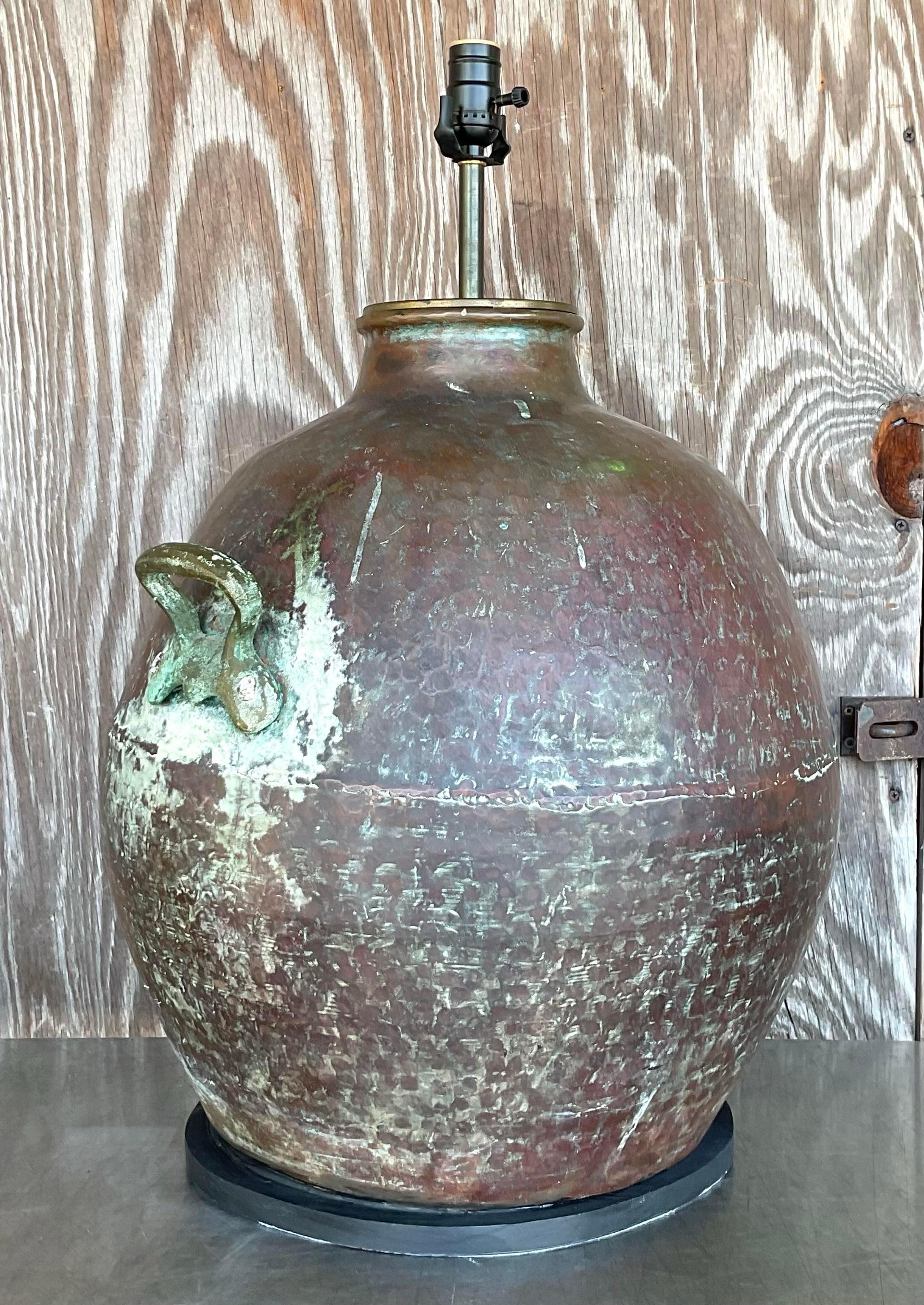 Make a statement with this Vintage Monumental Coastal Patinated Hammered Copper Lamp. Featuring an impressive size and a beautiful patinated hammered copper finish, this lamp brings a touch of coastal elegance and rustic charm to your decor. Perfect