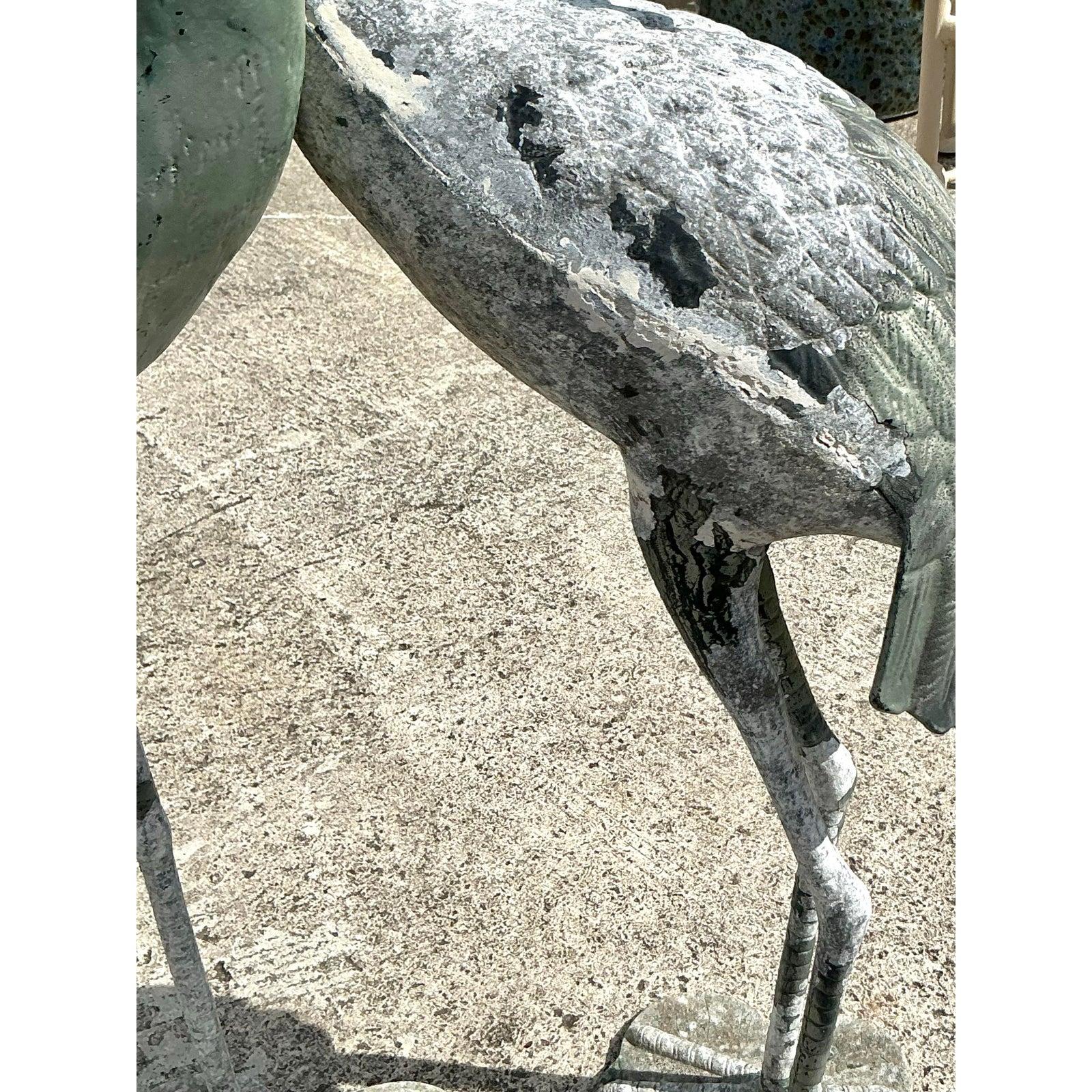 Porta un'eleganza costiera senza tempo nella tua casa o nel tuo giardino con questo splendido set di due sculture di gru in metallo vintage. Caratterizzate da forme aggraziate e allungate e da intricati dettagli di piume, queste statue emanano