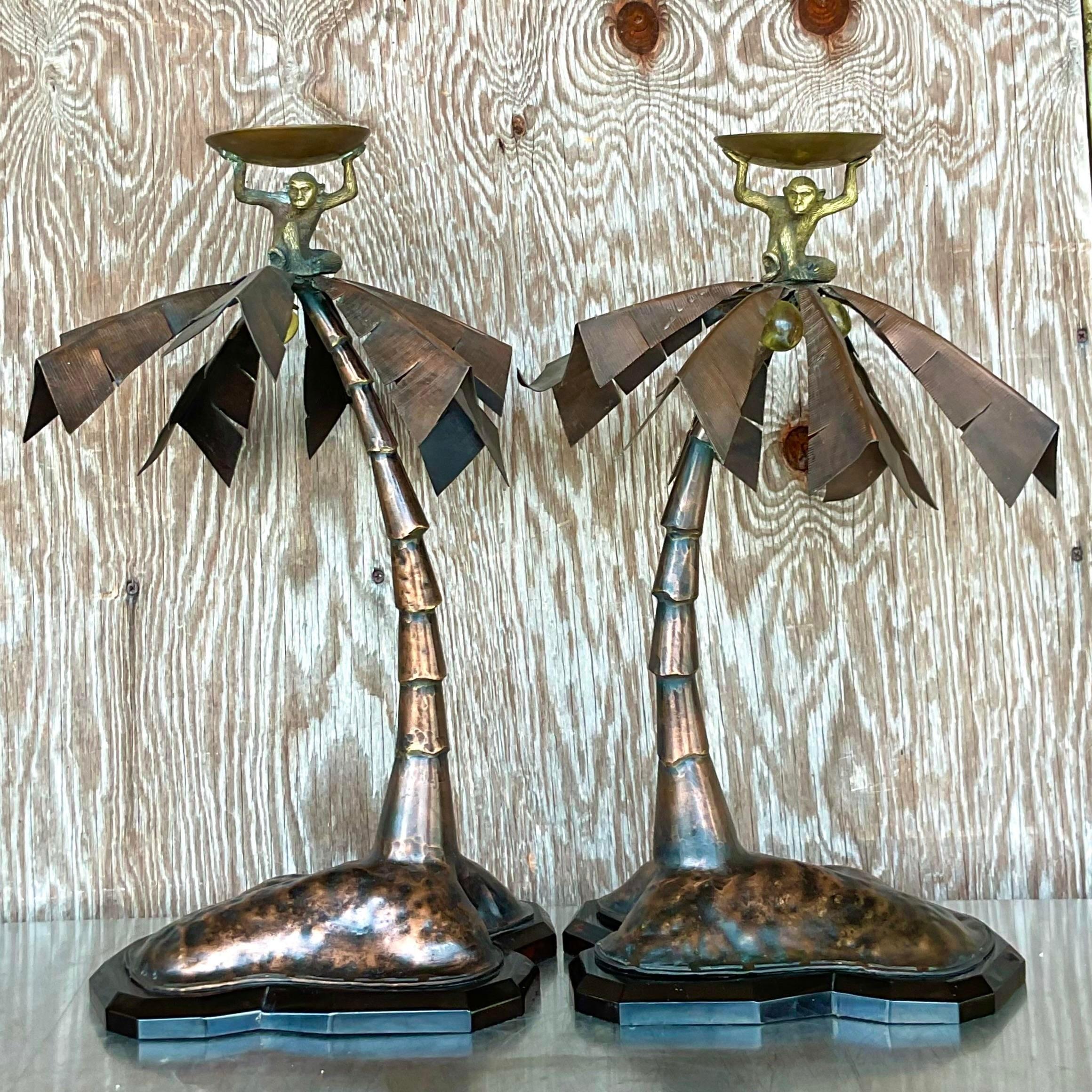 A fabulous pair of vintage Coastal candlesticks. Chic patinated metal palm trees with happy little monkeys holding up the plate for the candle. Little glass coconuts. Acquired from a Palm Beach estate.