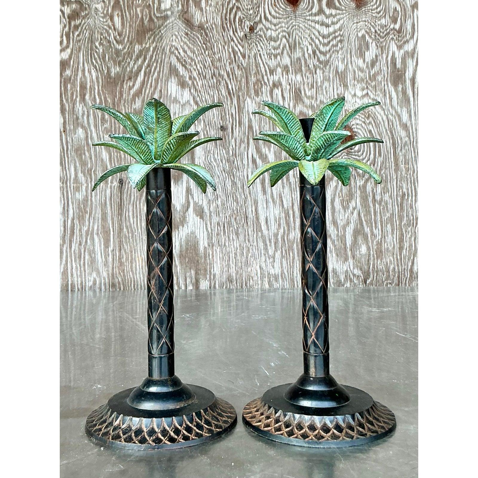 Aggiungi un accento tropicale al tuo arredamento con questa straordinaria coppia di candelabri vintage in stile palma. Ogni pezzo è caratterizzato da una base in metallo patinato scuro con dettagli intricati e un tronco intagliato che evoca la