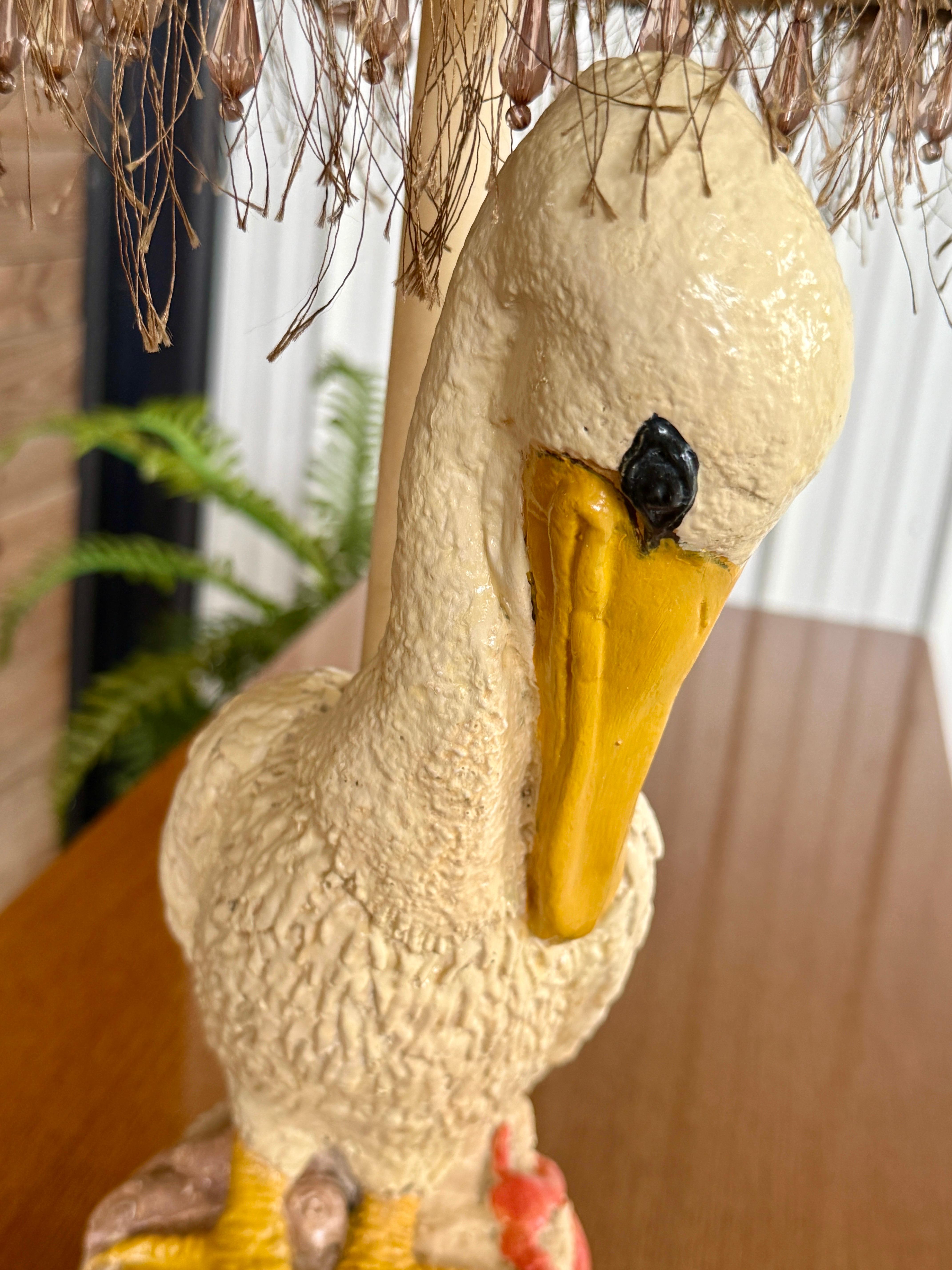 Lampe de table en plâtre vintage fantaisiste représentant un pélican perché à côté d'un homard rouge vif sur une base de style corde enroulée. Les détails peints à la main apportent une touche côtière charmante, ce qui en fait un accessoire