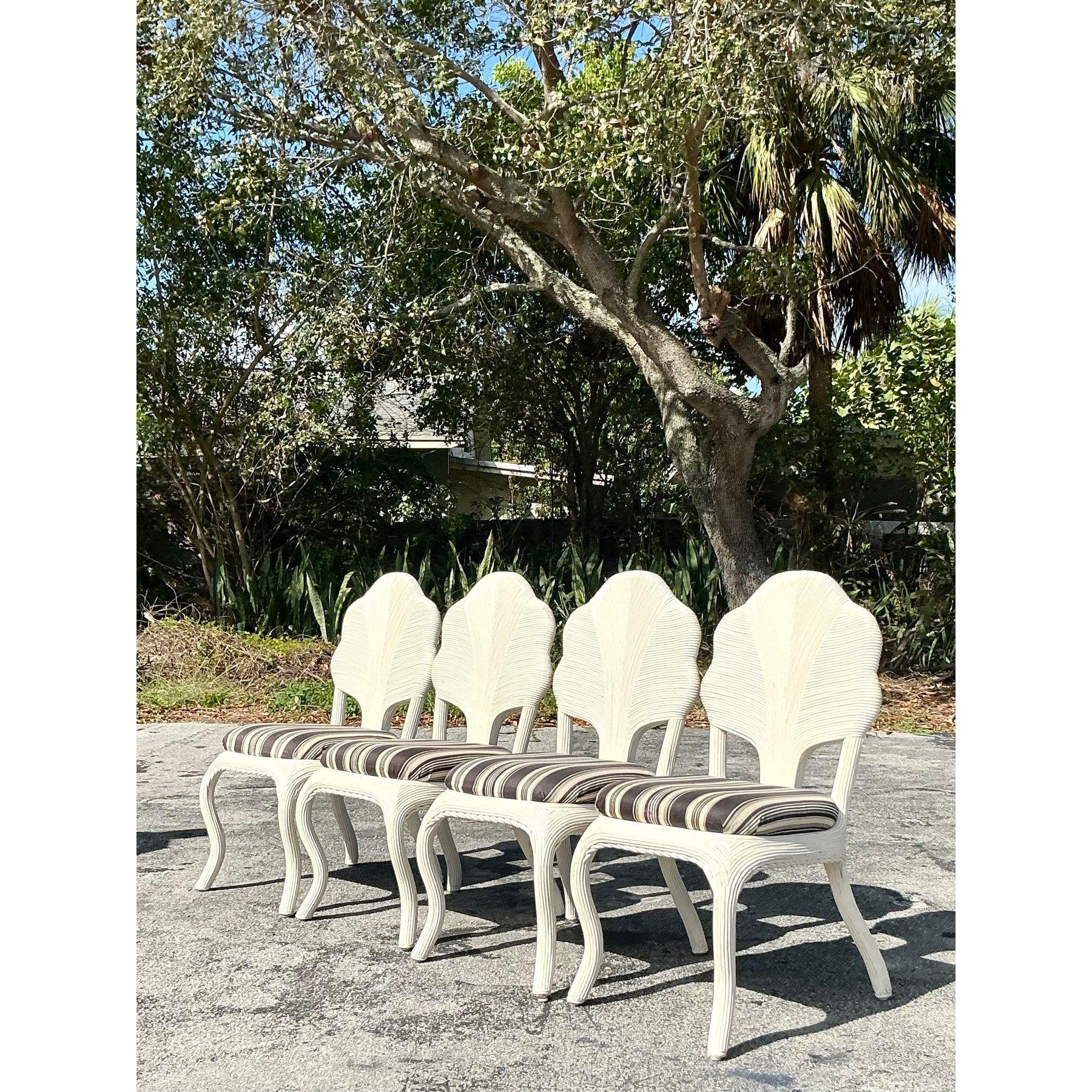 Elevate your dining space with this exquisite set of four vintage coastal dining chairs, masterfully crafted with intricate pencil reed detailing. Featuring an elegant flower-shaped backrest, these chairs bring a breezy, tropical charm reminiscent