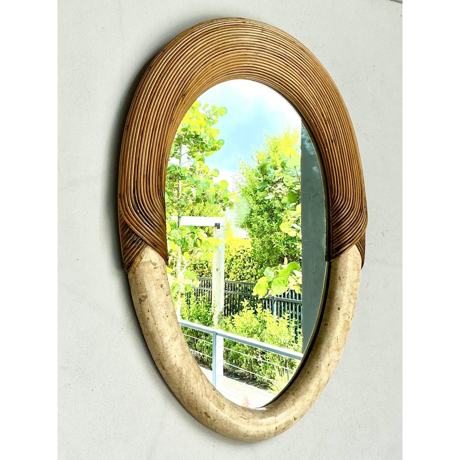 Infusez votre espace avec une sophistication côtière grâce à ce miroir vintage en roseau et pierre. D'une élégante forme ovale, le cadre est habilement enveloppé d'un roseau chaud et mielleux en haut, qui se transforme en une pierre lisse et