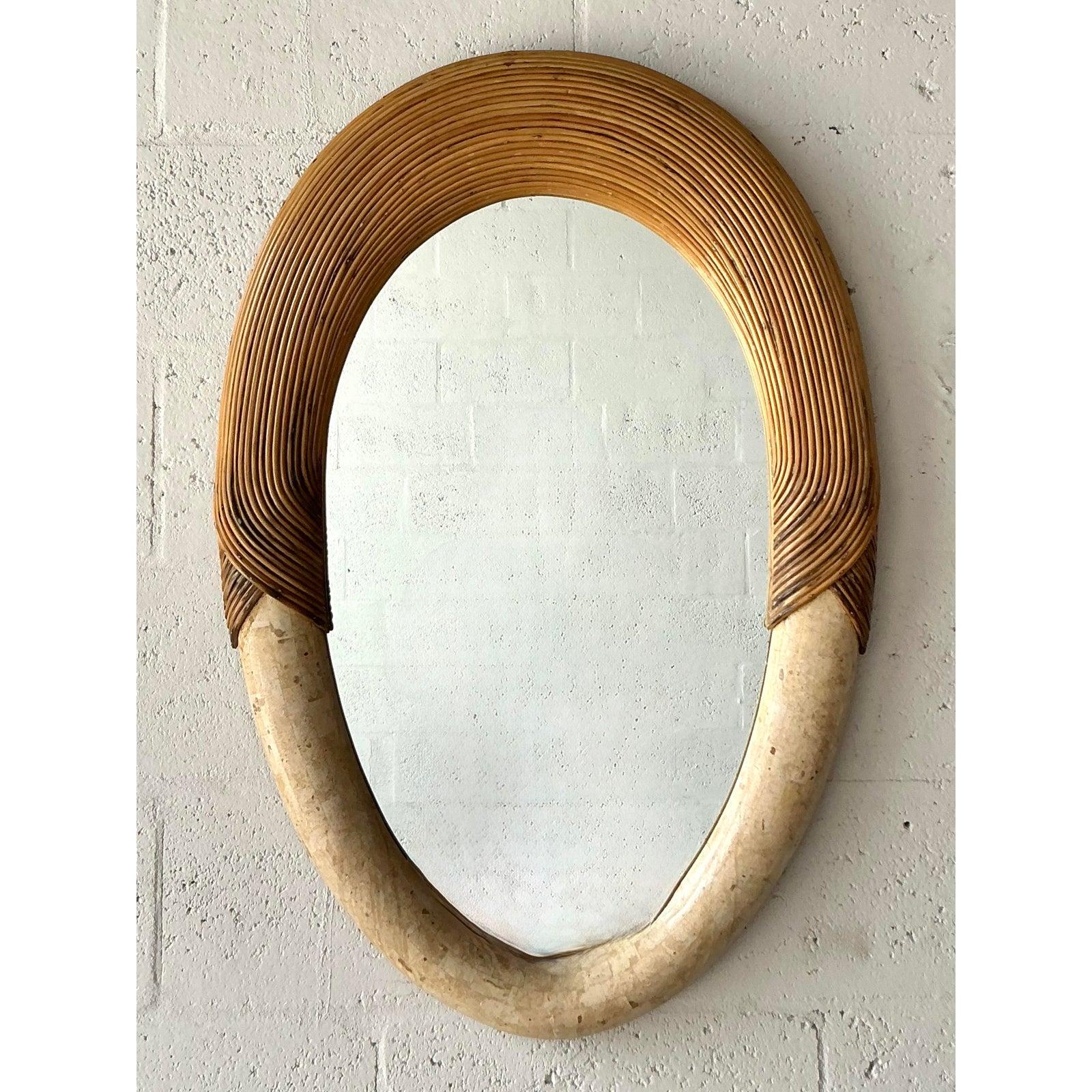 Eleganza senza sforzo del design costiero con questo eccezionale specchio vintage. Questo pezzo è una miscela magistrale di texture organiche, con una struttura meticolosamente realizzata in rattan di canna da zucchero, che si trasforma con grazia