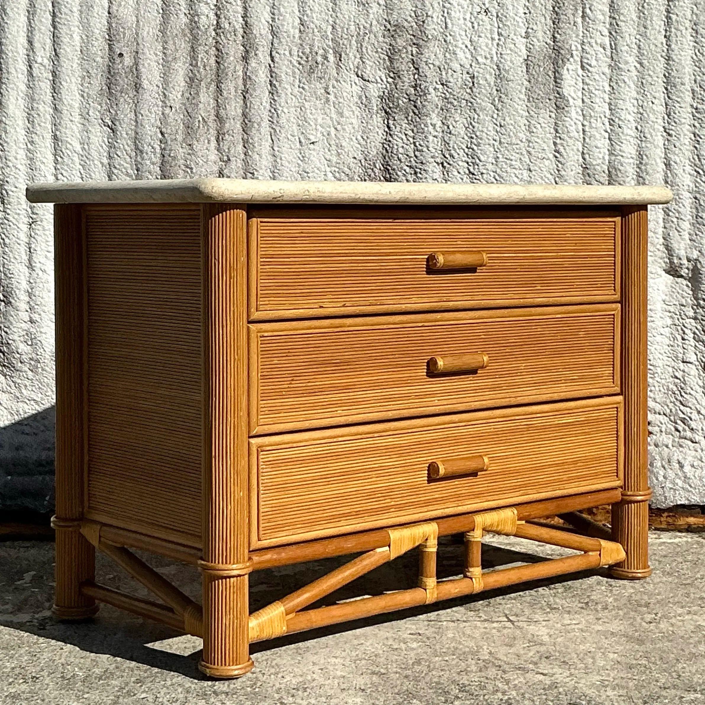 Questa cassettiera in legno di canna e pietra tessellata della Costa d'Epoca unisce texture naturali ed eleganti lavorazioni artigianali. La struttura è caratterizzata da una canna finemente intrecciata che aggiunge un'estetica calda e costiera,