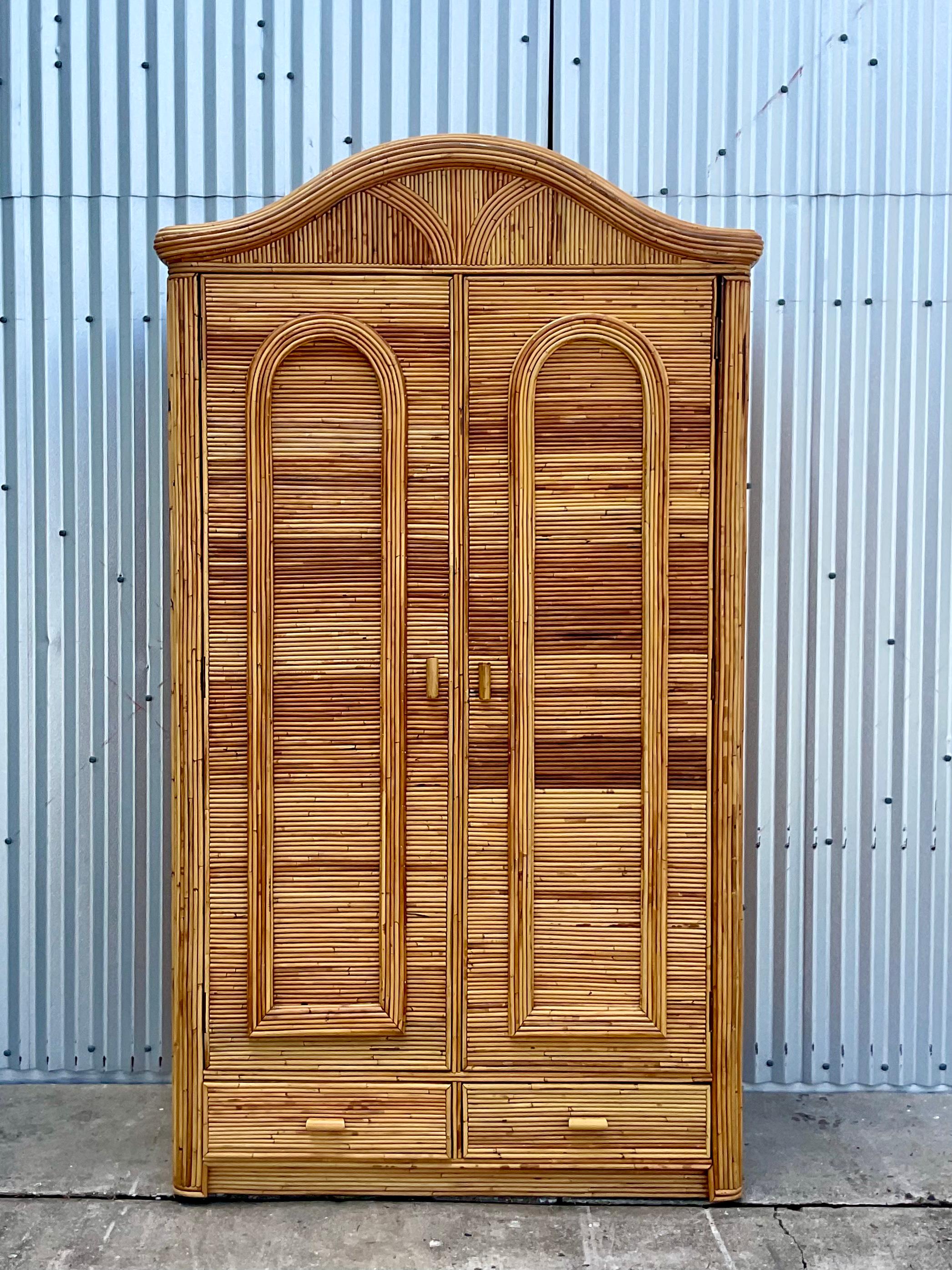 Fantastic vintage pencil reed armoire. Gorgeous coastal look in a dramatic shape. Perfect as is for additional storage or mirror the interior and make it a chic bar. You decide! Acquired from a Palm Beach estate.