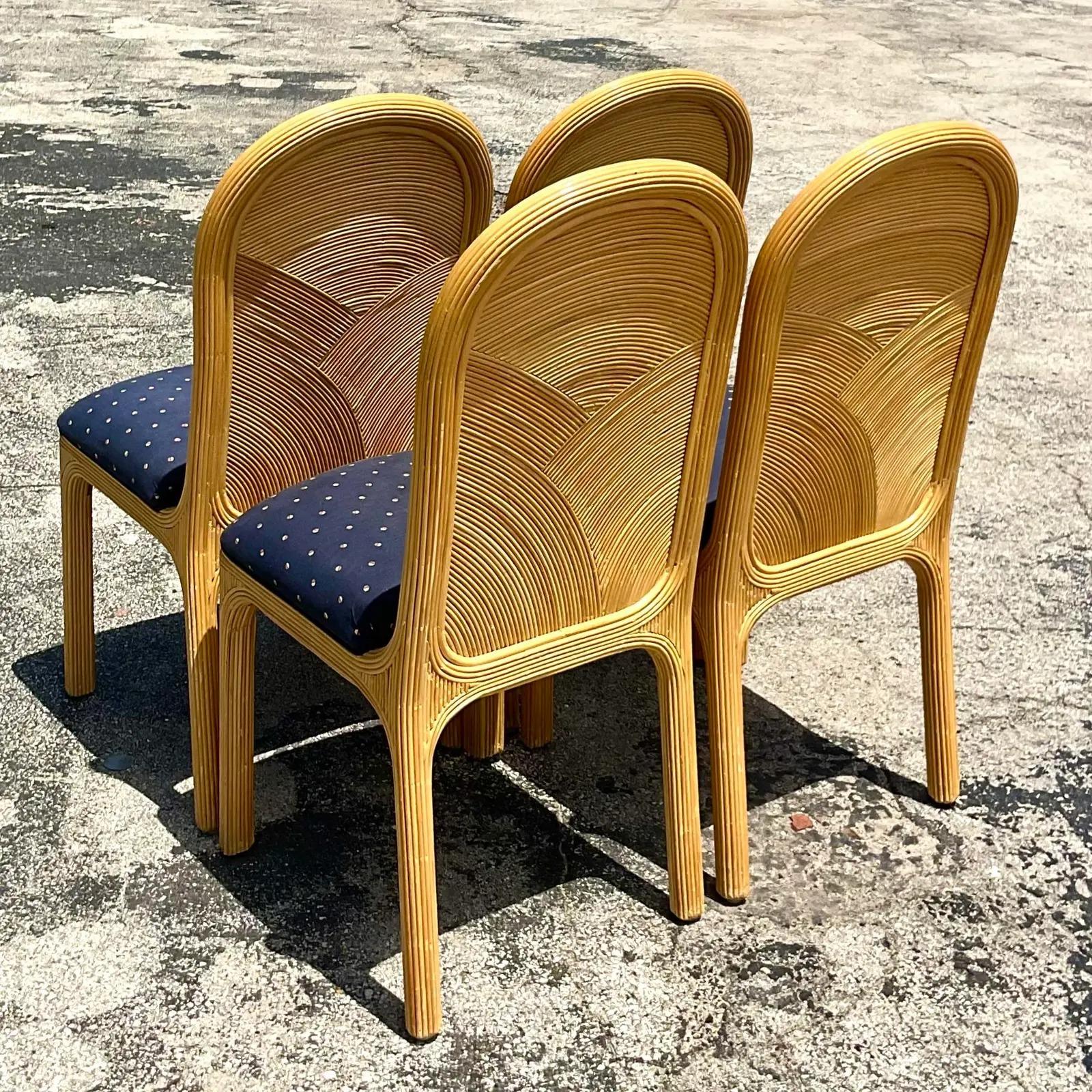 Fantastic set of four vintage Coastal dining chairs. Beautiful arched pencil reed design. Four additional chairs with different upholstery also available. Acquired from a Palm Beach estate.