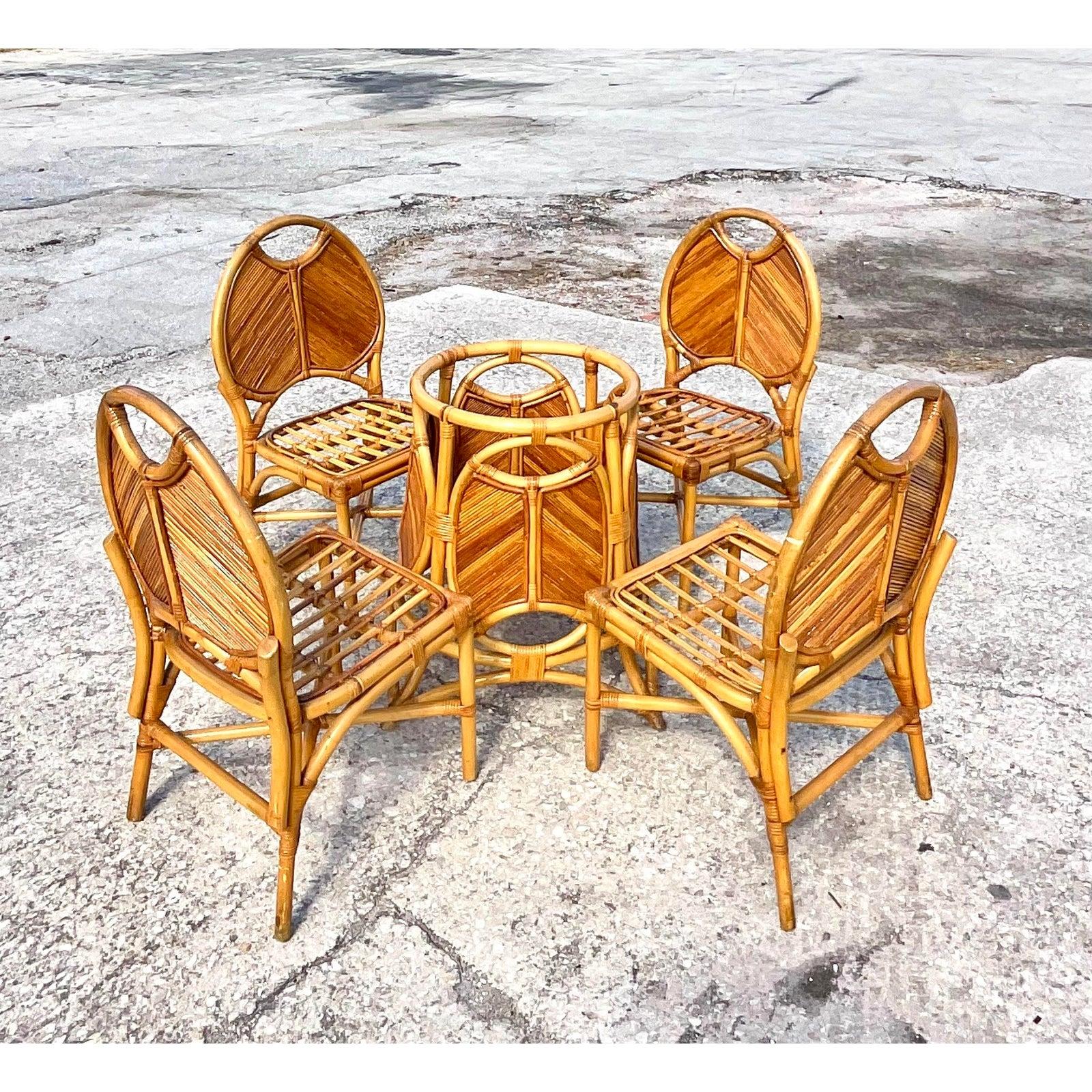 A spectacular set of vintage coastal dining chairs and pedestal. Beautiful natural pencil reed in a chic Chevron design. The same design is repeated in the pedestal for the table. The pedestal can handle glass up to 60 inches. Acquired from a Palm