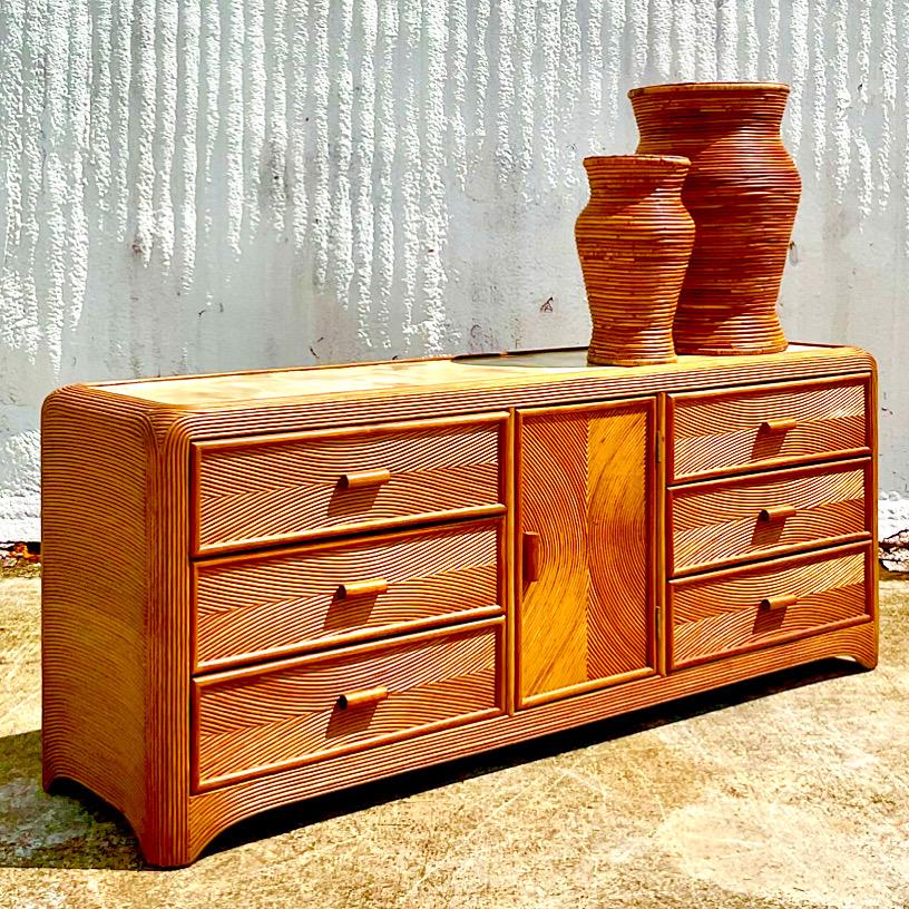 Fantastic vintage Coastal dresser. Beautiful warm pencil reed in a rich brown color. Chic directional design. Three additional drawers behind the center door. A hand painted faux finish on top. Acquired from a Palm Beach estate.