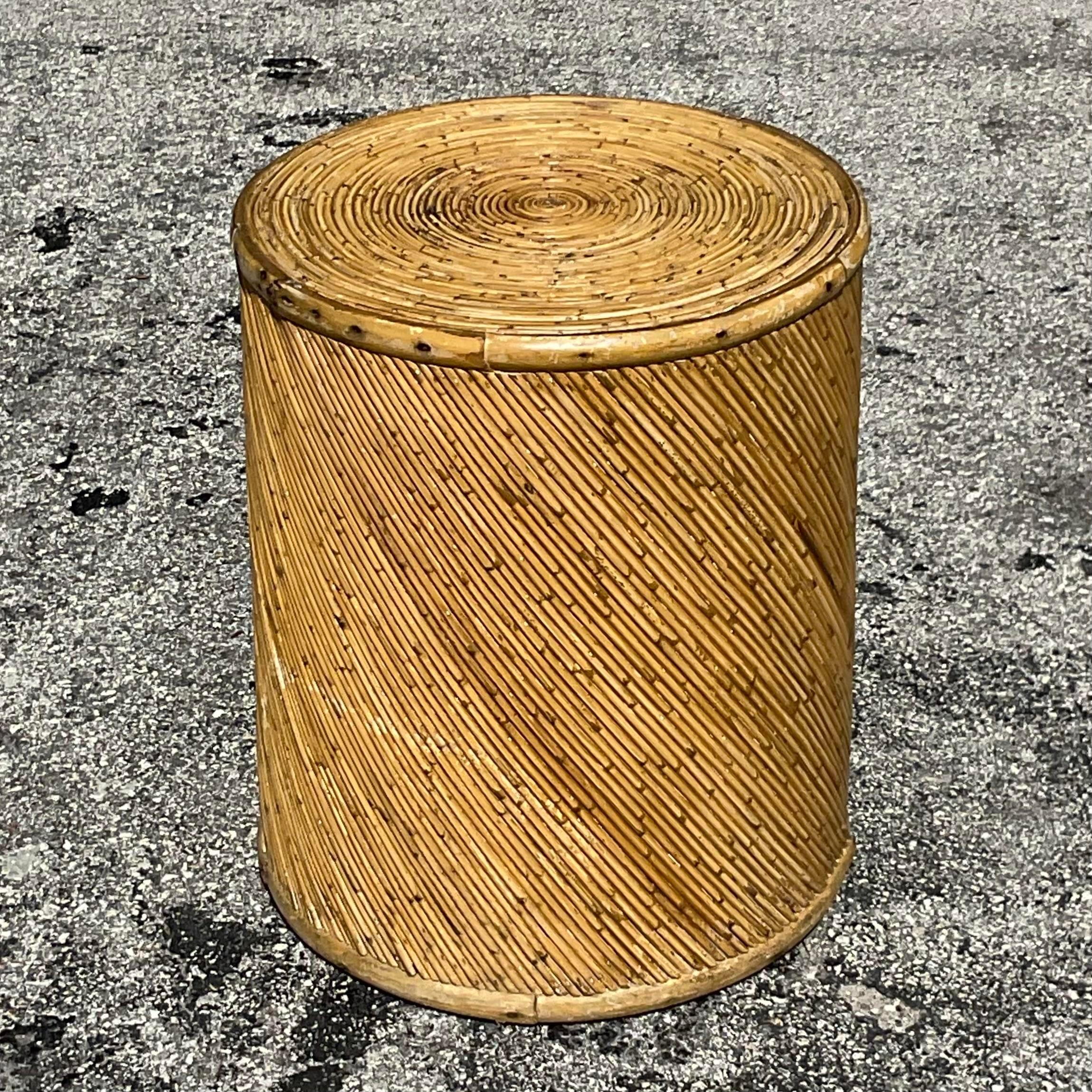 Bringen Sie den Charme der Küste in Ihr Zuhause mit dem Vintage Coastal Pencil Reed Drum Side Table. Dieses Möbelstück im amerikanischen Stil zeichnet sich durch eine filigrane Bleistiftrohrkonstruktion in einer Trommelsilhouette aus und bietet eine