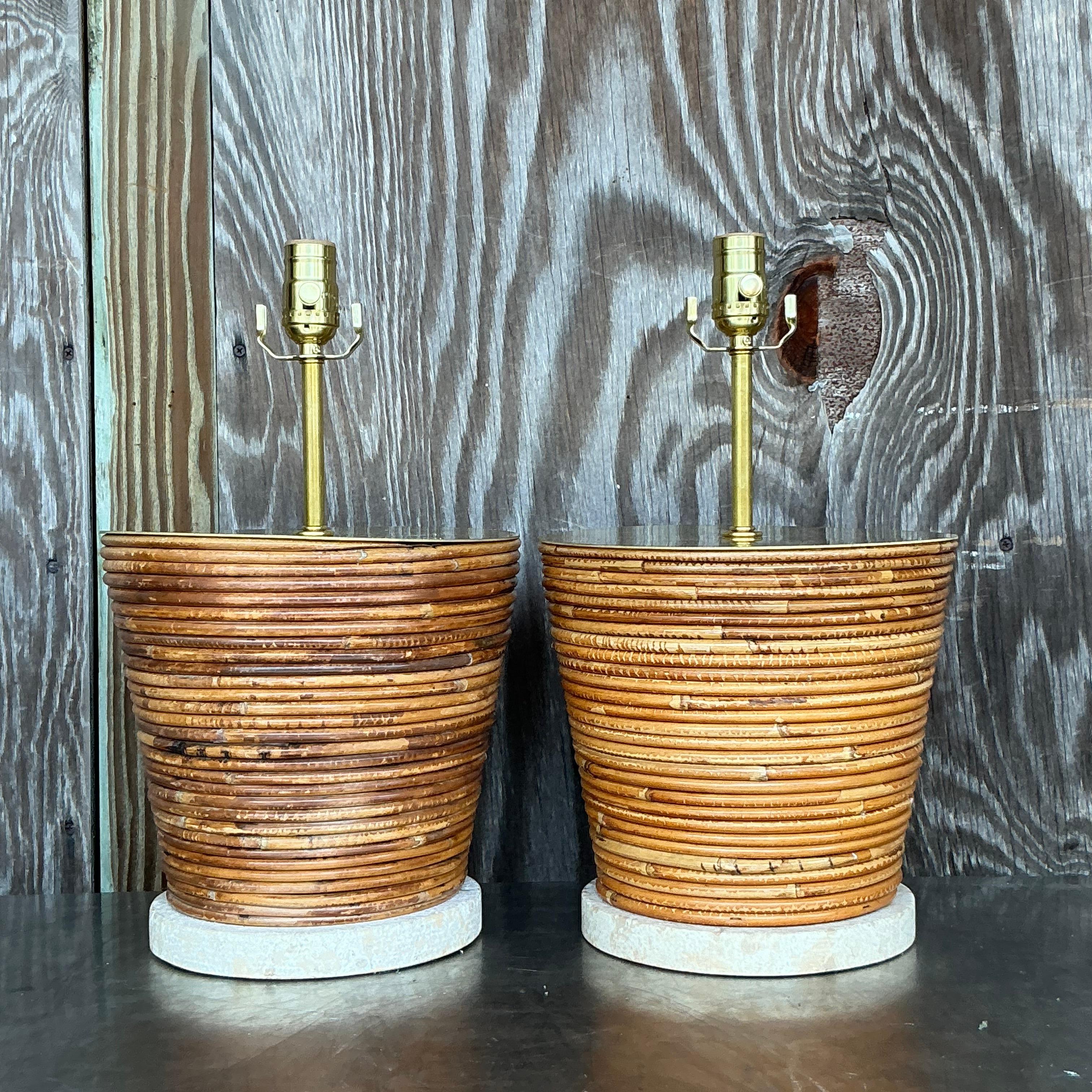 Infuse your space with coastal elegance using this stunning pair of vintage pencil reed lamps with brass hardware. These lamps feature beautifully textured pencil reed bases, perfectly complemented by sleek brass accents for a touch of