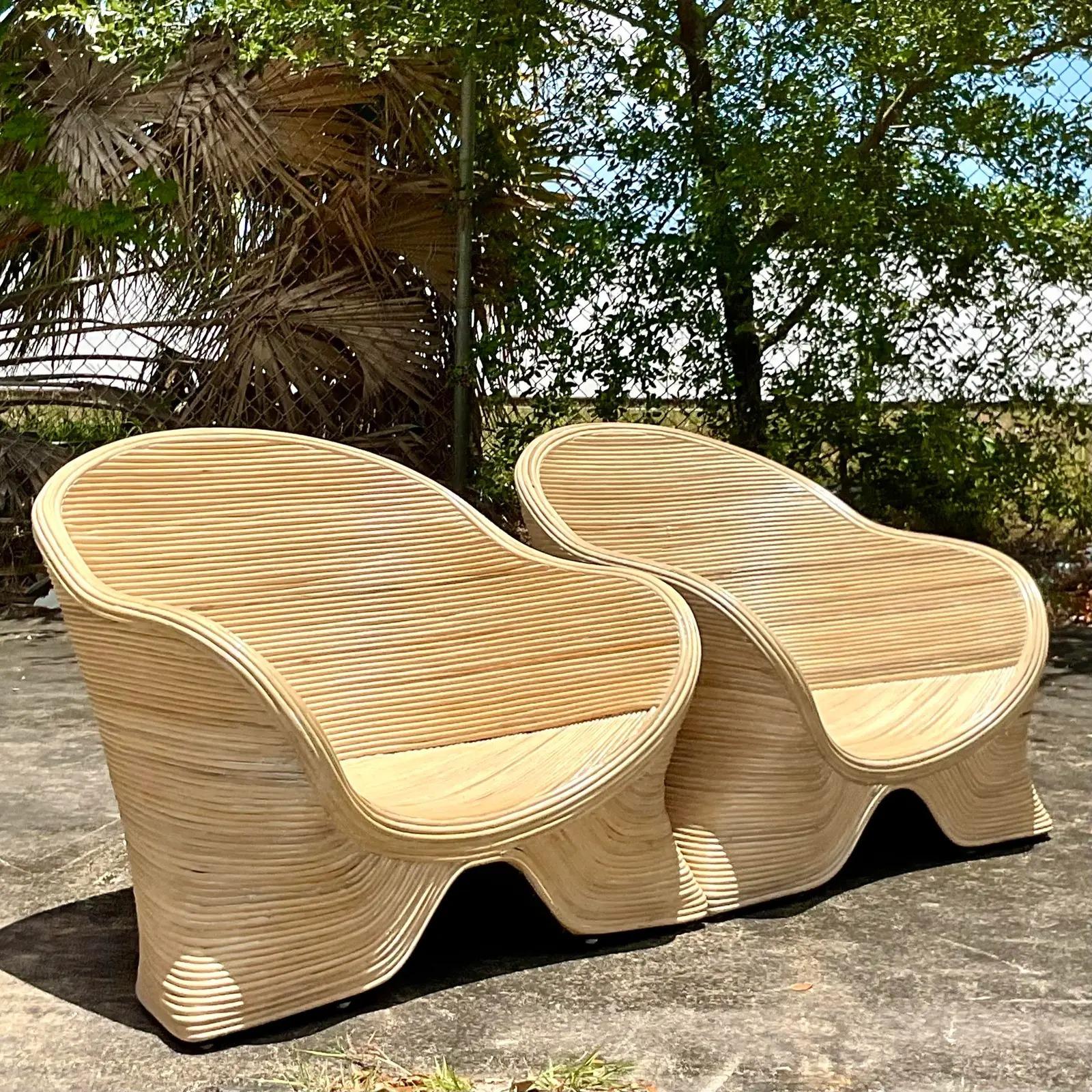 Fantastic pair of Coastal lounge chairs. Low and sexy profile make them a great addition to any décor. Made from a bright pencil reed in an organic shape. Acquired from a Palm Beach estate.