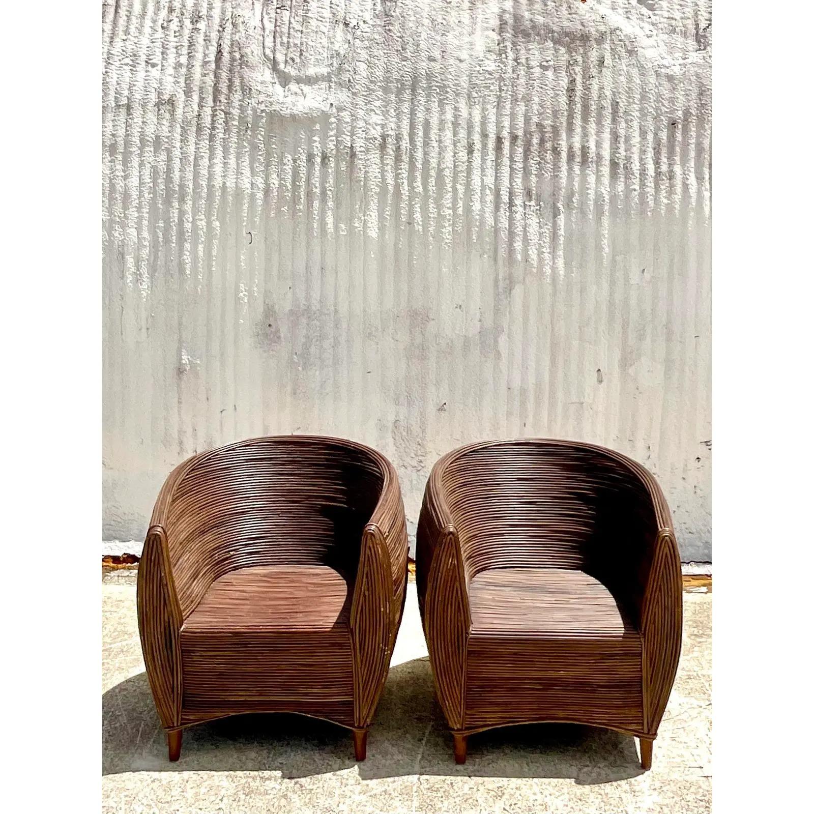 A fantastic pair of vintage Coastal pod chairs. Super chic pod shape constructed with coiled pencil reed in a deep brown color. Raised on four legs. Acquired from a Palm Beach estate.