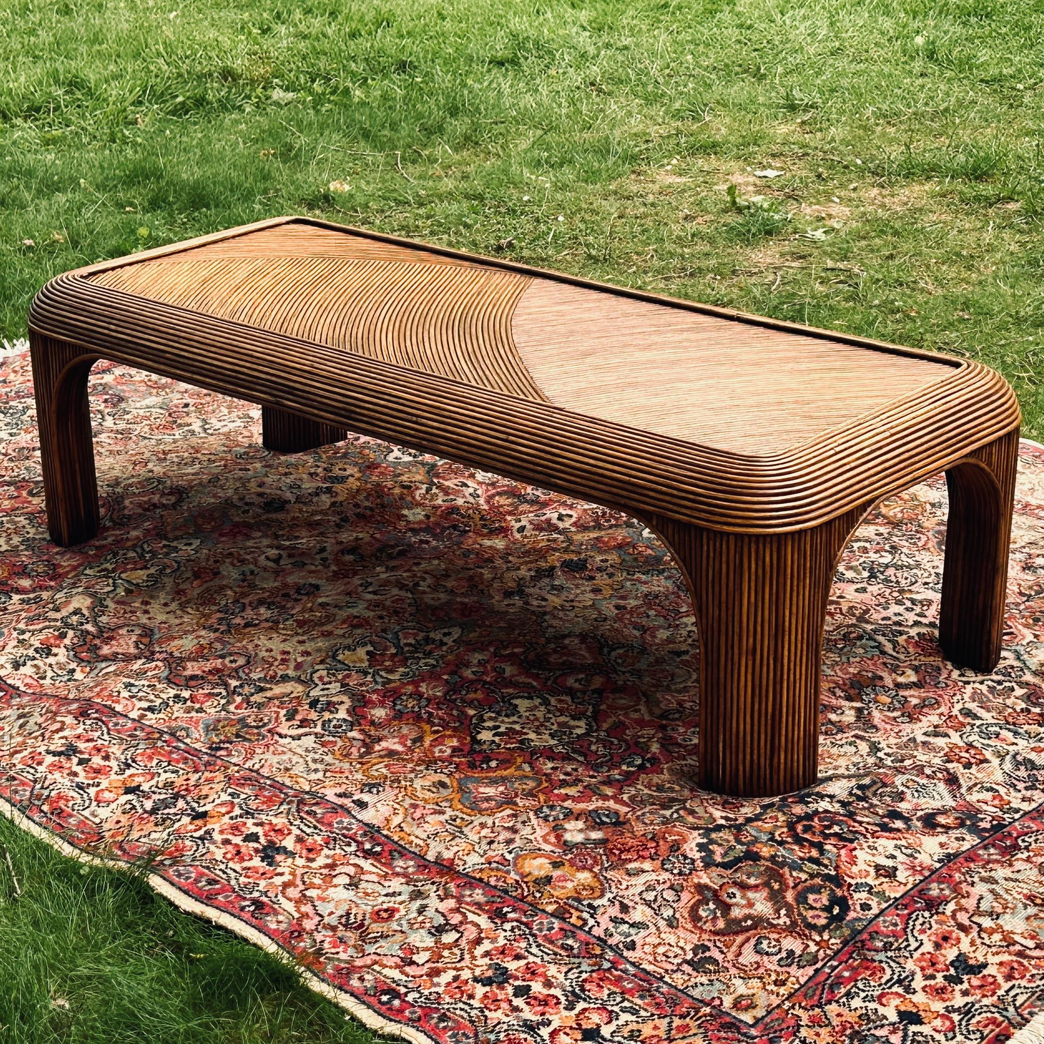 Fantastic vintage pencil reed coffee table. Beautiful swirl design on the top in a classic waterfall shape. Acquired from a Main Line estate. Can be used with or without the inset glass glass surface measuring roughly 19” x 49”