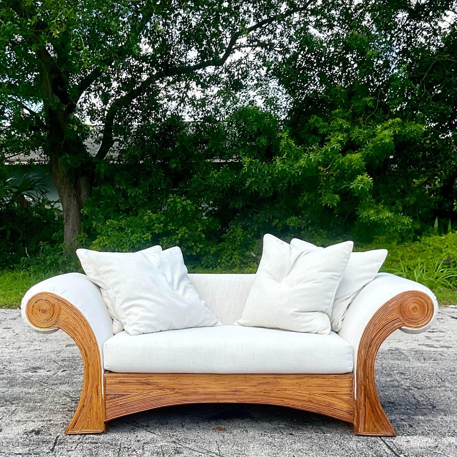 A fabulous vintage Coastal sofa. A chic pencil reed frame with a roll arm design. Newly upholstered in an oatmeal linen cotton. Acquired from a Palm Beach estate.