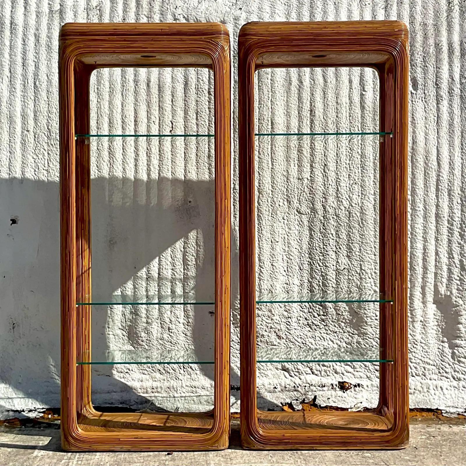 A fabulous pair of vintage Coastal etagere. Beautiful pencil reed frame with the coveted starburst design. Inset glass shelves. Acquired from a Palm Beach estate.