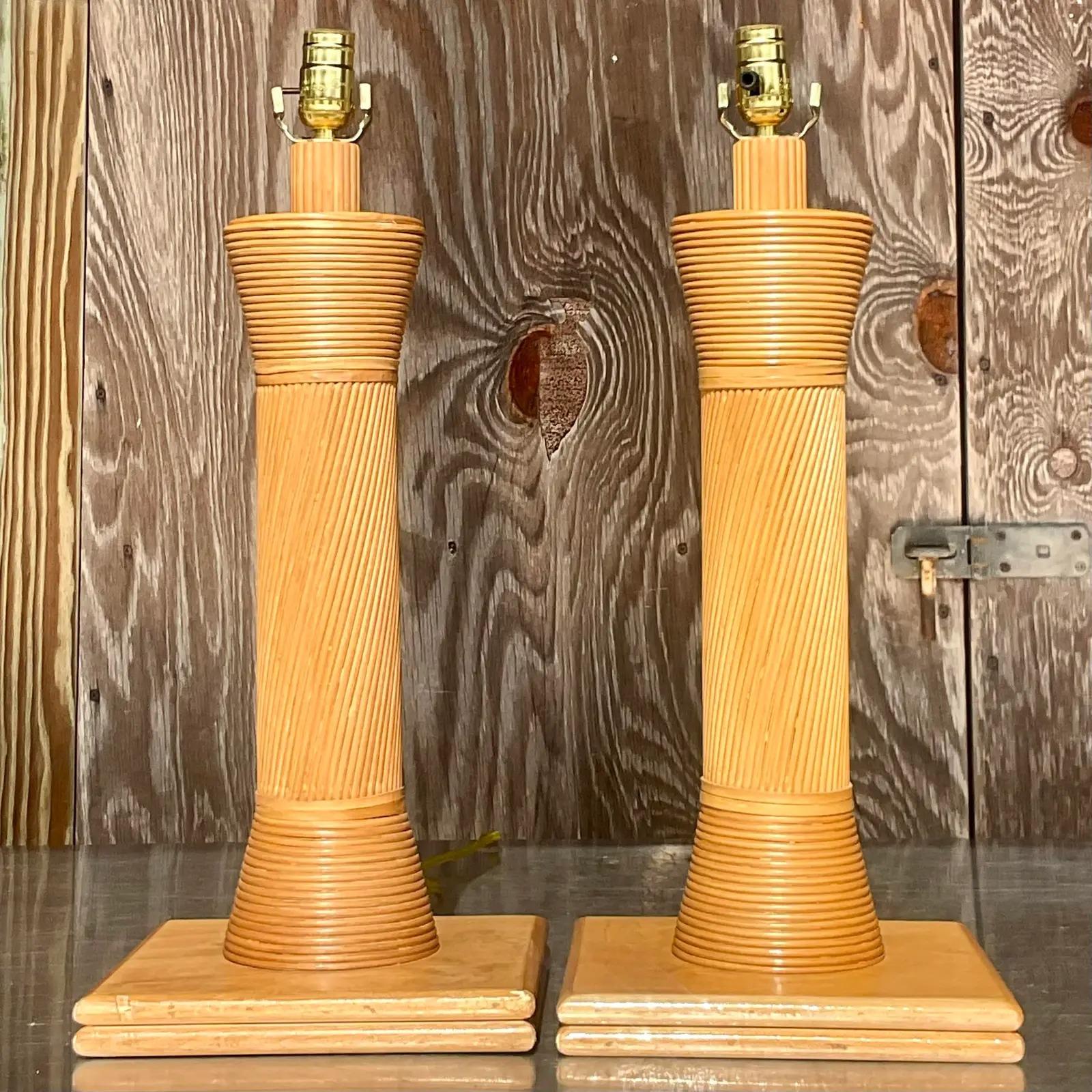 A spectacular pair of vintage Coastal table lamps. Beautiful pencil reed in a chic multi directional design. Rest on wood plinths. Acquired from a Palm Beach estate.