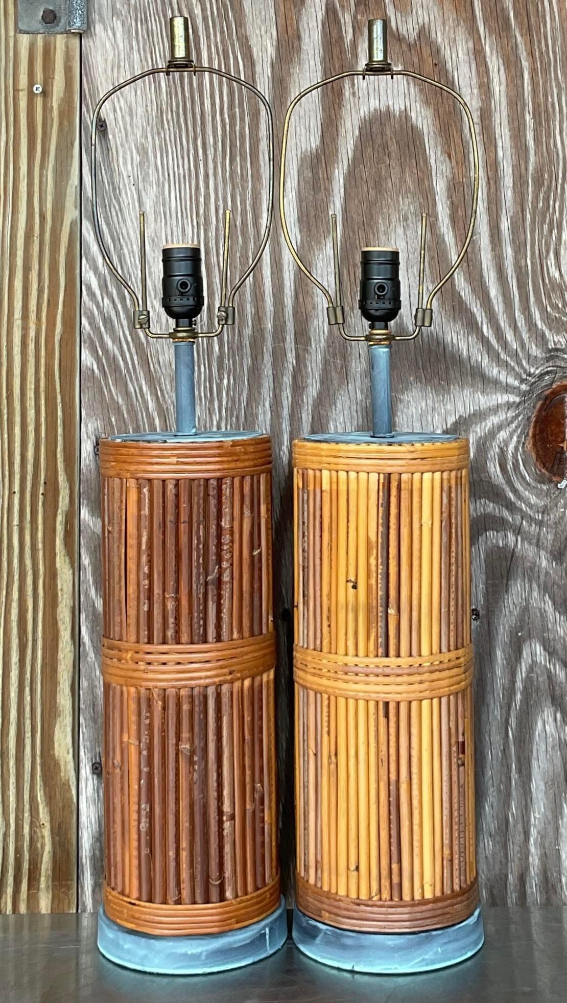 Beleuchten Sie Ihren Raum mit küstennahem Charme mit diesem Paar Vintage Pencil Reed Tischlampen. Inspiriert von der klassischen amerikanischen Küstenästhetik, strahlen diese Lampen mit ihrem komplizierten gewebten Design und den natürlichen