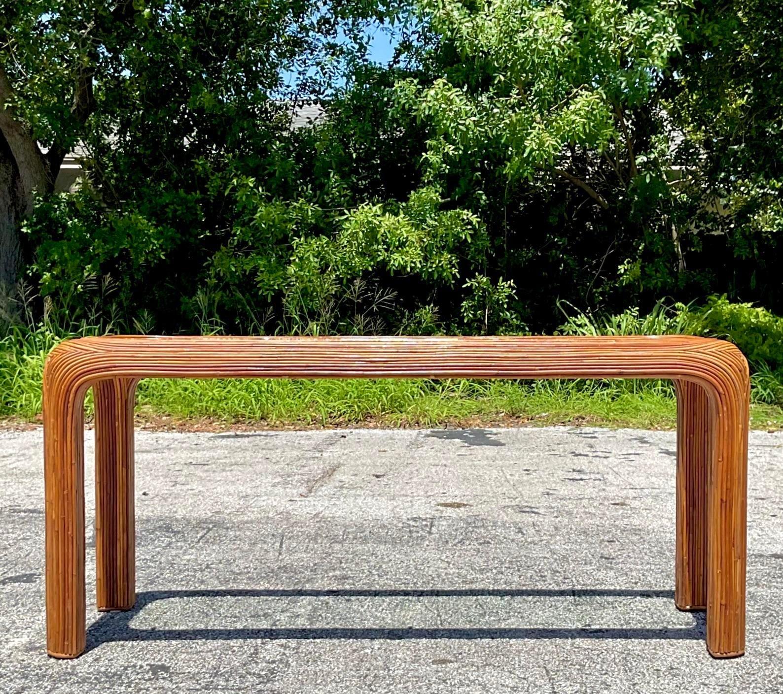 Elevate your décor with this Vintage Coastal Pencil Reed Waterfall Console Table. Its unique waterfall design and intricate pencil reed detailing bring a touch of coastal elegance to any space. Perfect for entryways or living areas, this console