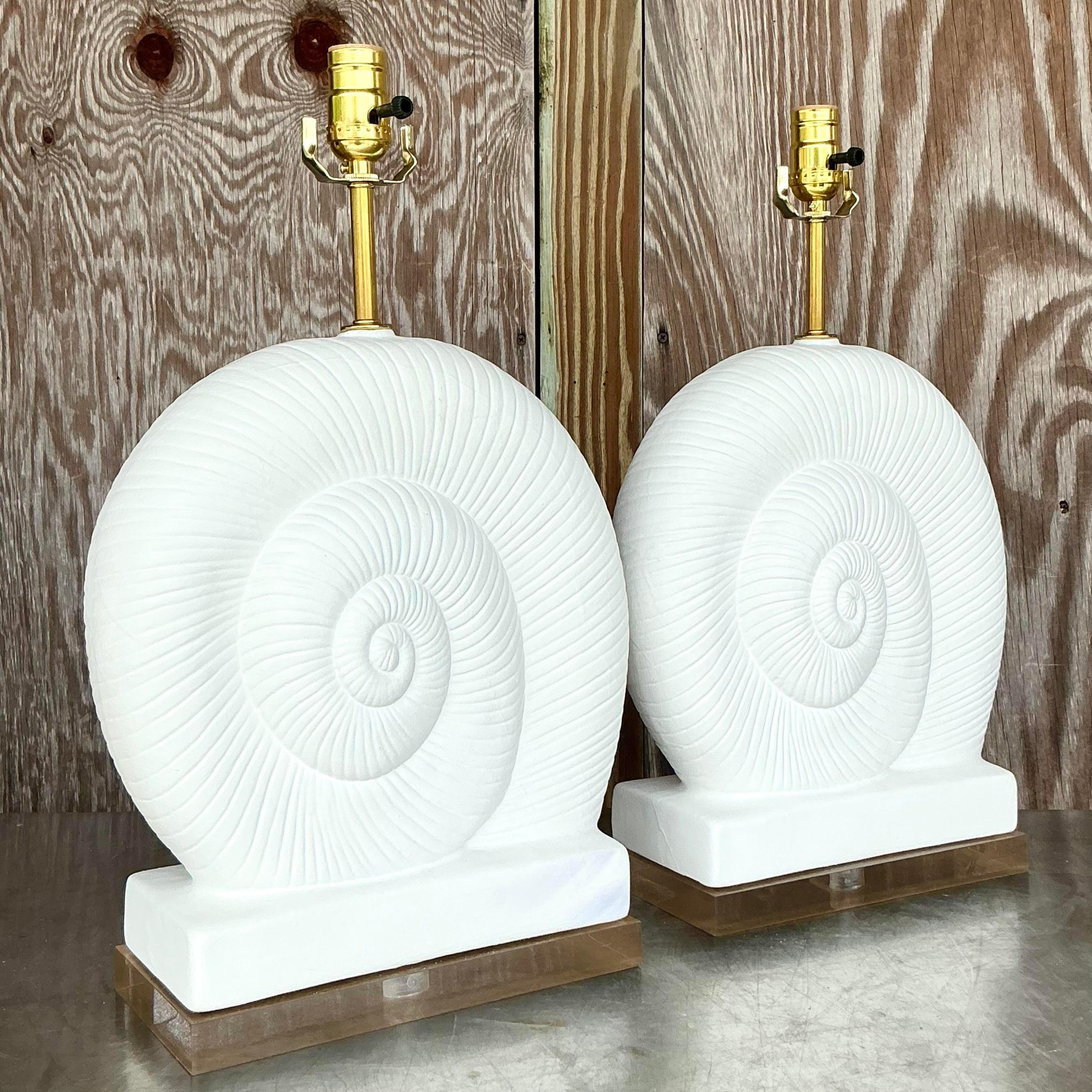 Verschönern Sie Ihr Zuhause mit diesem atemberaubenden Paar Nautilus Muschel-Lampen aus Gips und Lucite im Vintage-Stil. Diese Lampen im amerikanischen Stil vereinen die organische Eleganz von Nautilusmuscheln mit der eleganten Raffinesse von Lucite