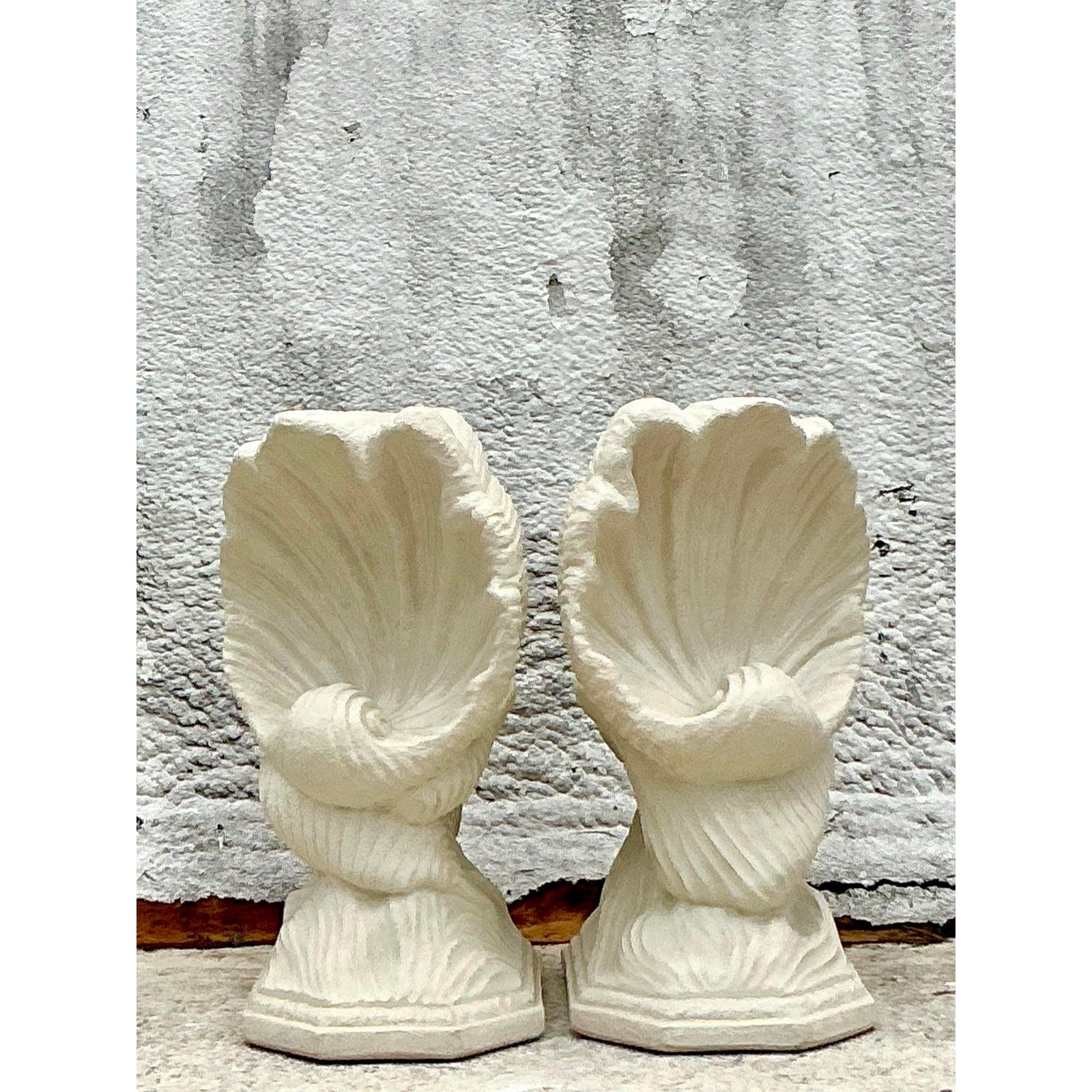 Introduce an unparalleled touch of coastal elegance and sculptural grandeur with this exquisite Vintage Coastal Plaster Clam Shell Table Pedestal Set. Each meticulously crafted pedestal replicates the organic, fluted beauty of a natural clam shell,