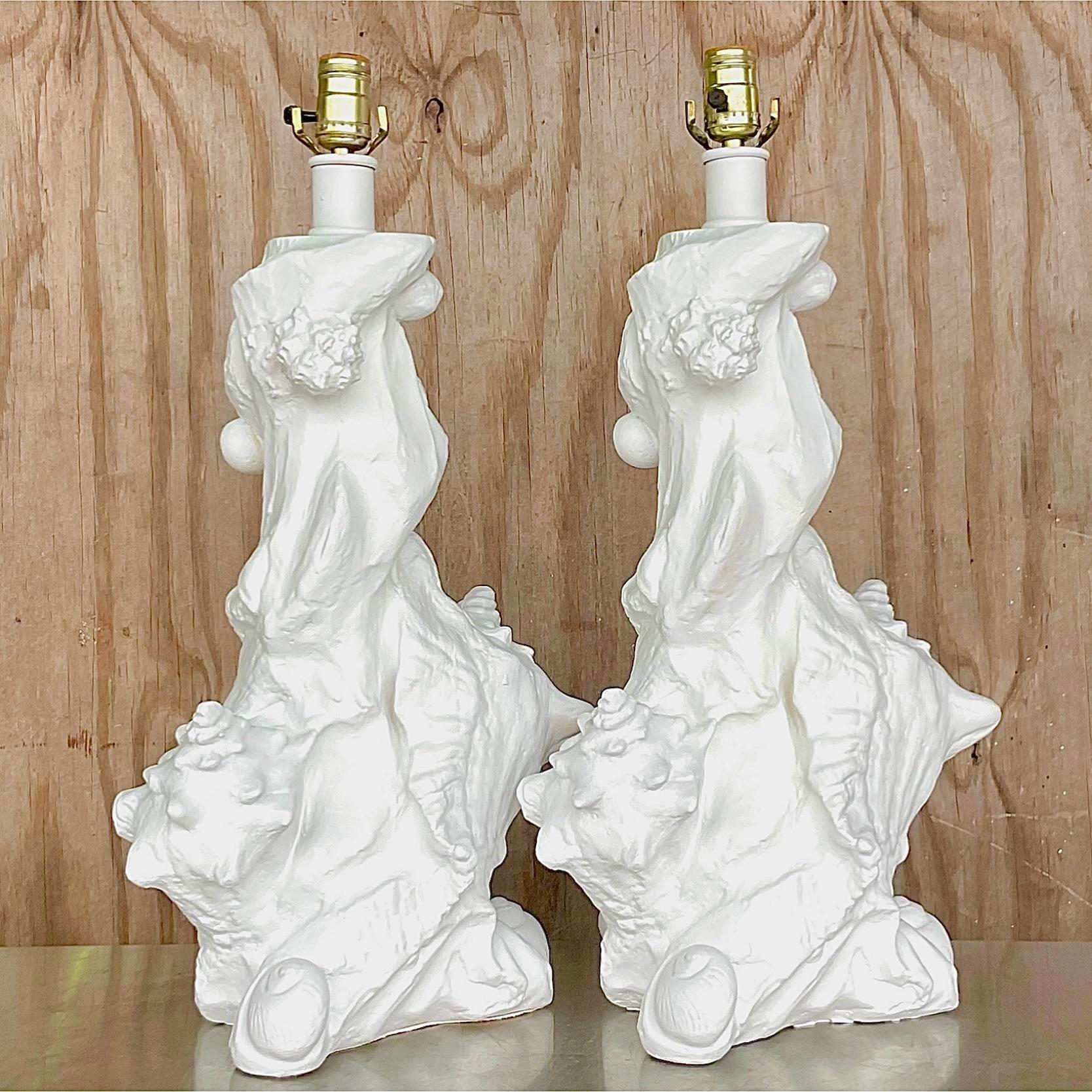 An exceptional pair of vintage Coastal table lamps. A chic plaster sculptural design filled with shells and conch shells. Done in the manner of Sirmos. Acquired from a Miami estate.