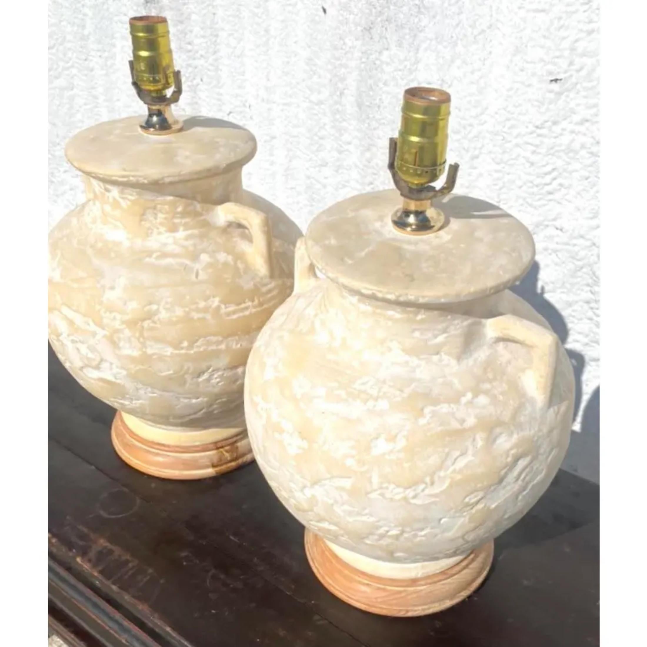 Fabulous pair of vintage plaster urn lamps. Beautiful textured finish that rests on a lime wash plinth. A lovely pale color. Acquired from a Palm Beach estate.