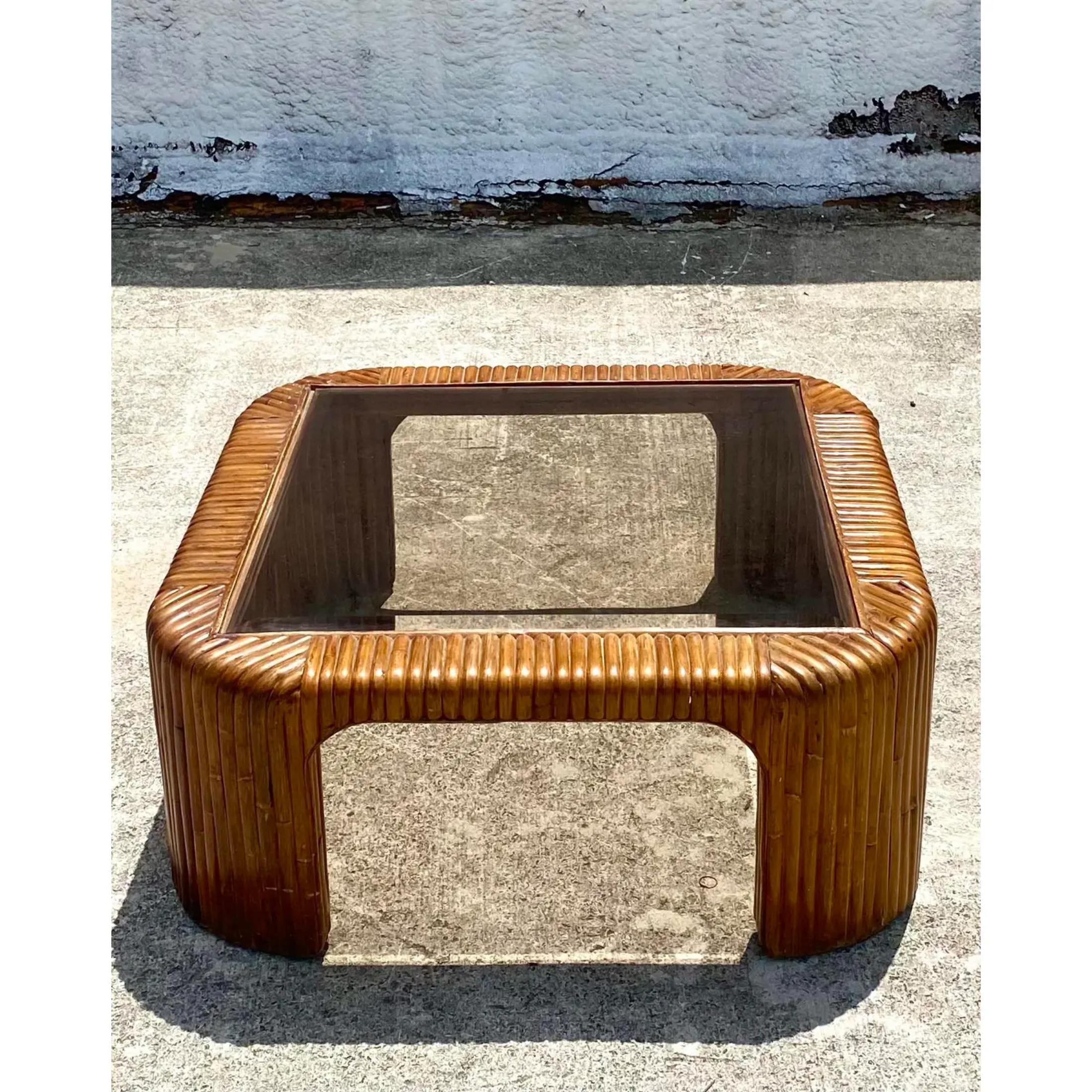 A fabulous vintage Coastal coffee table. Beautiful rich brown pretzel rattan in a beautiful waterfall design. Inset tinted glass top. Acquired from a Palm Beach estate