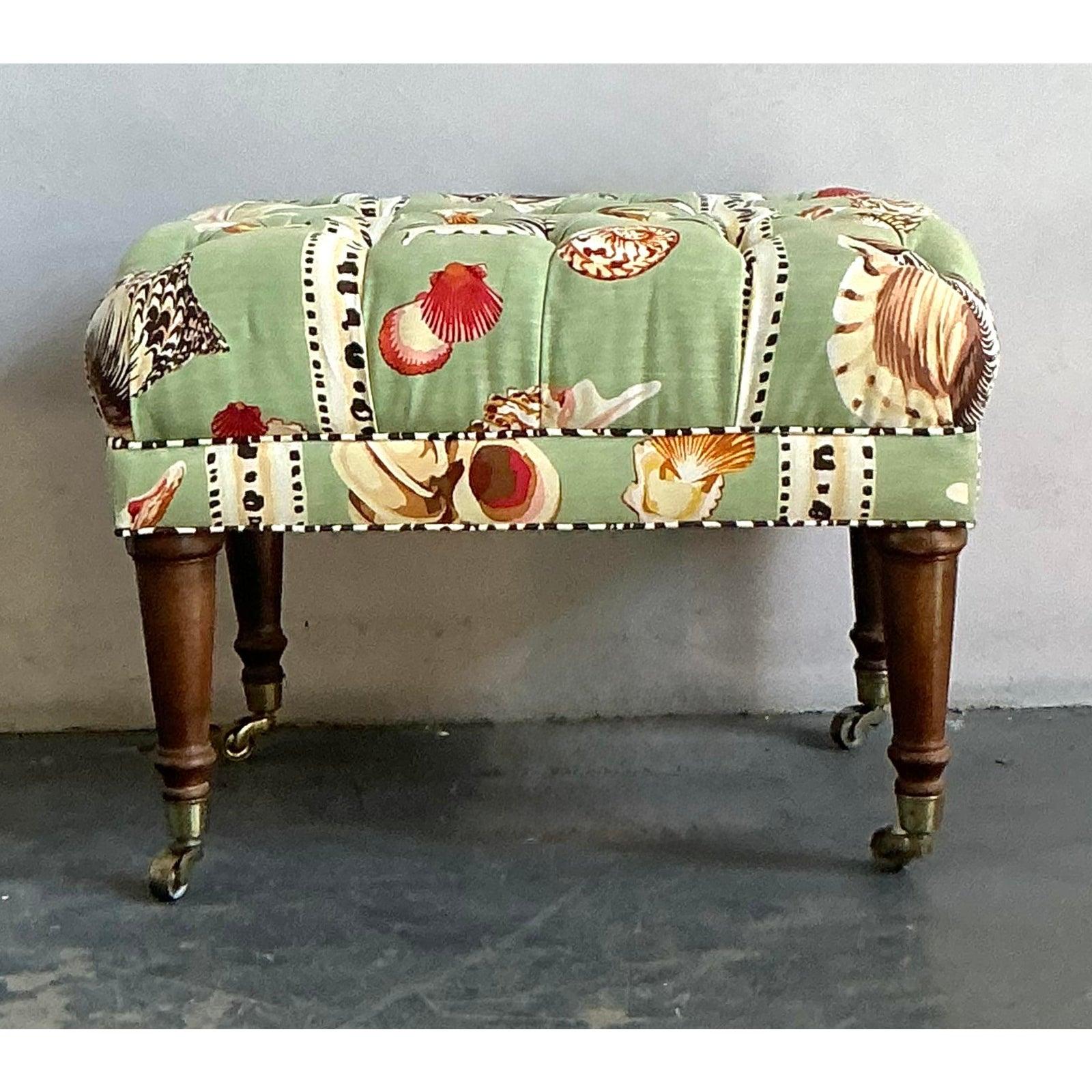 Enhance your living space with this charming vintage Coastal Chic tufted ottoman, upholstered in a delightful shell-printed fabric. This elegant ottoman features a captivating pattern of diverse seashells in warm, natural hues set against a soft