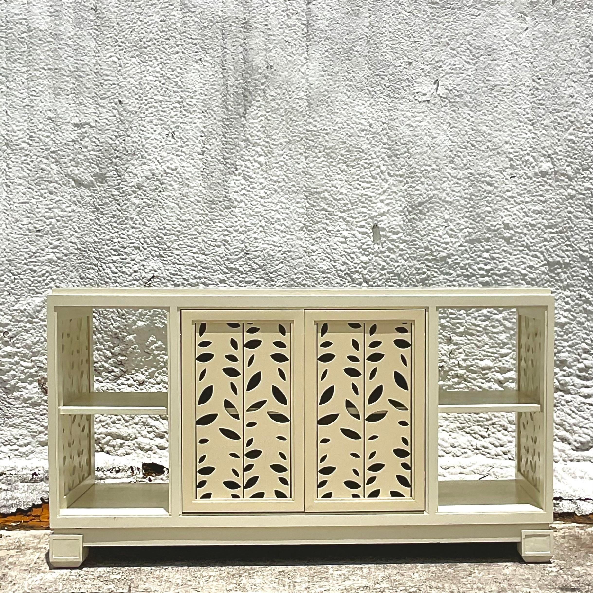 A fabulous vintage Coastal credenza. Chic punch cut doors and sides with a leaf motif. Acquired from a Palm Beach estate.