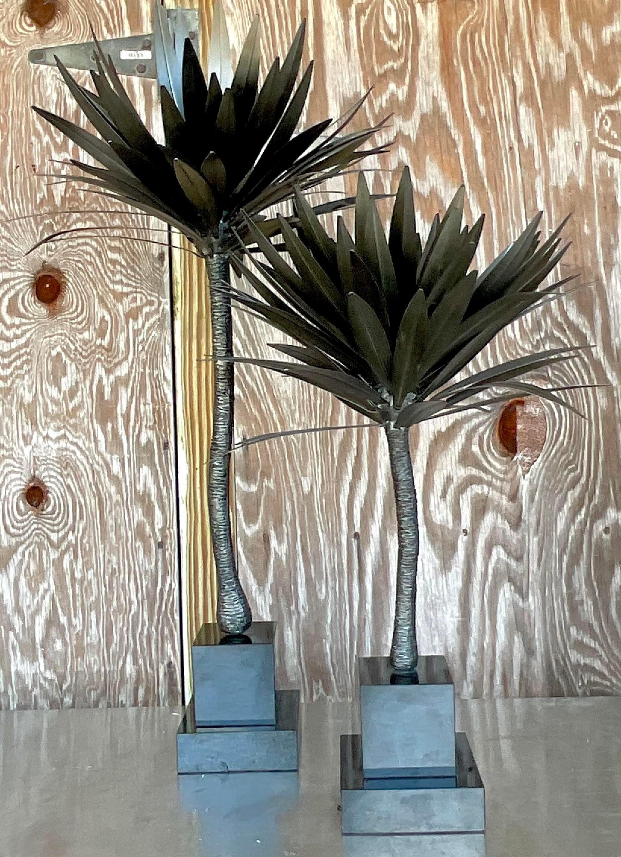A fantastic pair of vintage Coastal palm trees. Beautiful dark bronze finish on punch cut metal on black marble plinths. Acquired from a Palm Beach estate.

Smaller tree height 28 