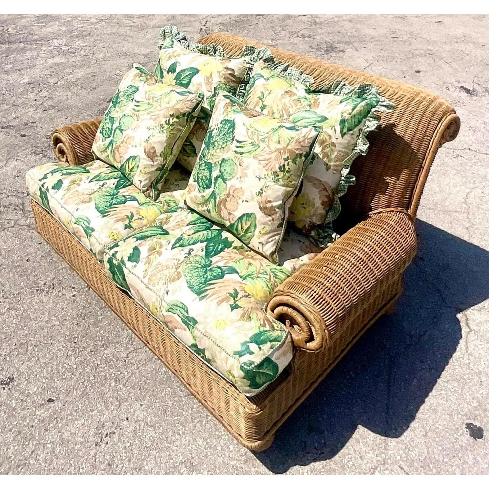 Fantastic vintage Coastal loveseat. Made by the iconic Ralph Lauren Home Group. Chic woven rattan on a roll arm design. Charming floral print upholstery with ruffle trim. Acquired from a Palm Beach estate.
