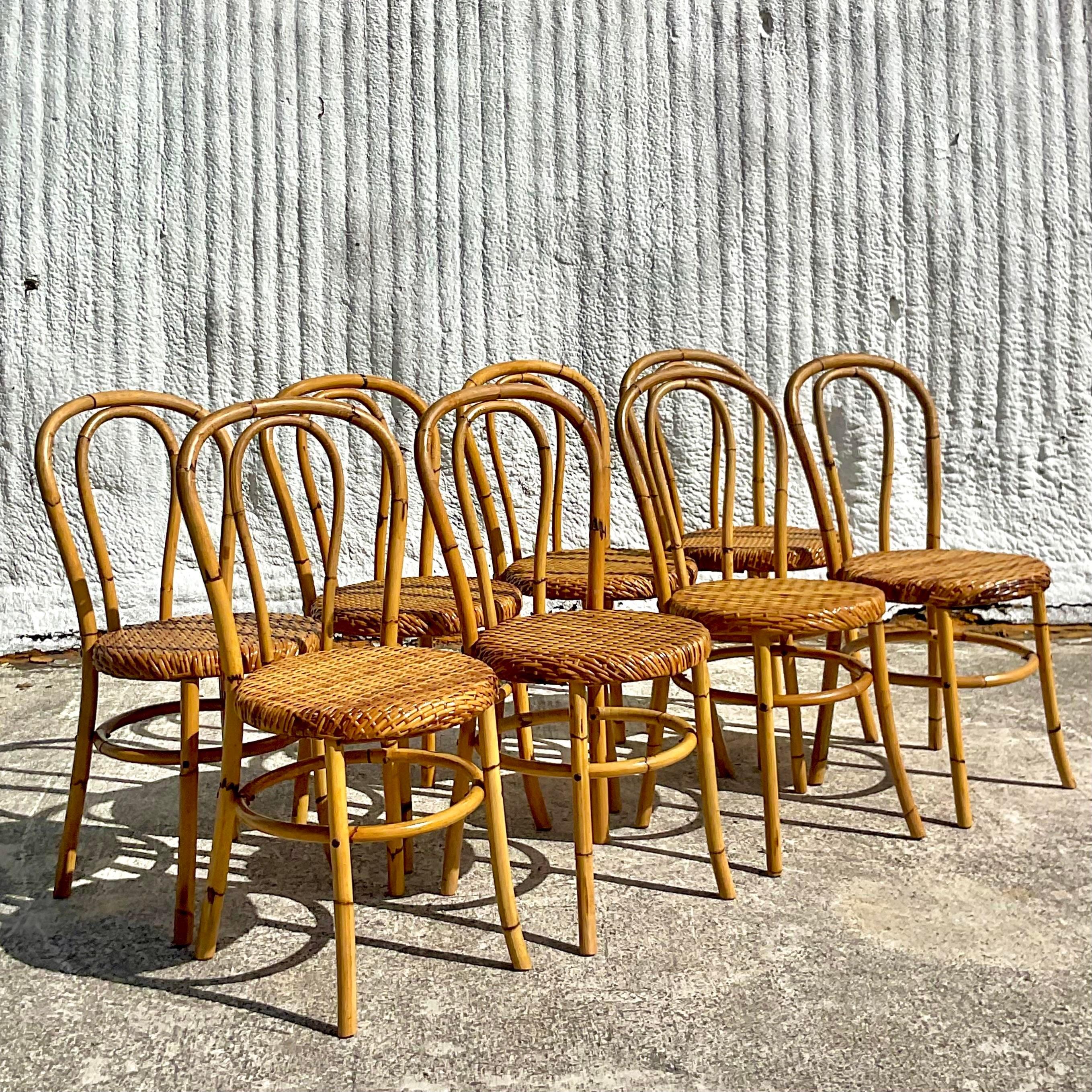 A spectacular vintage set of 8 rare coastal dining chairs. Made by the iconic McGuire group of San Francisco. Beautiful bent bamboo with a woven rattan seat. Tagged on the bottom. Acquired from a Palm Beach estate.