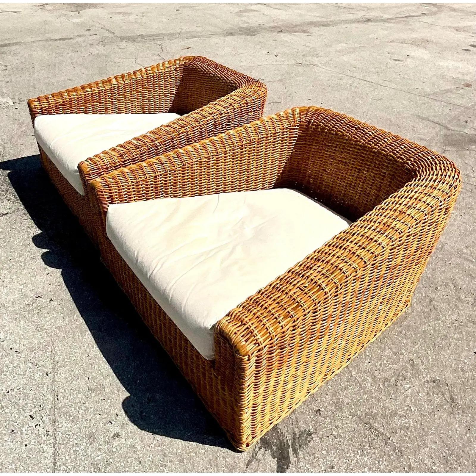 Incredible pair of vintage coastal lounge chairs. Designed by the incomparable Michael Taylor. Produced by Wicker Wicker California. A chic angular shape and white cotton duck upholstery. Matching sofa also available. Acquired from a Palm Beach