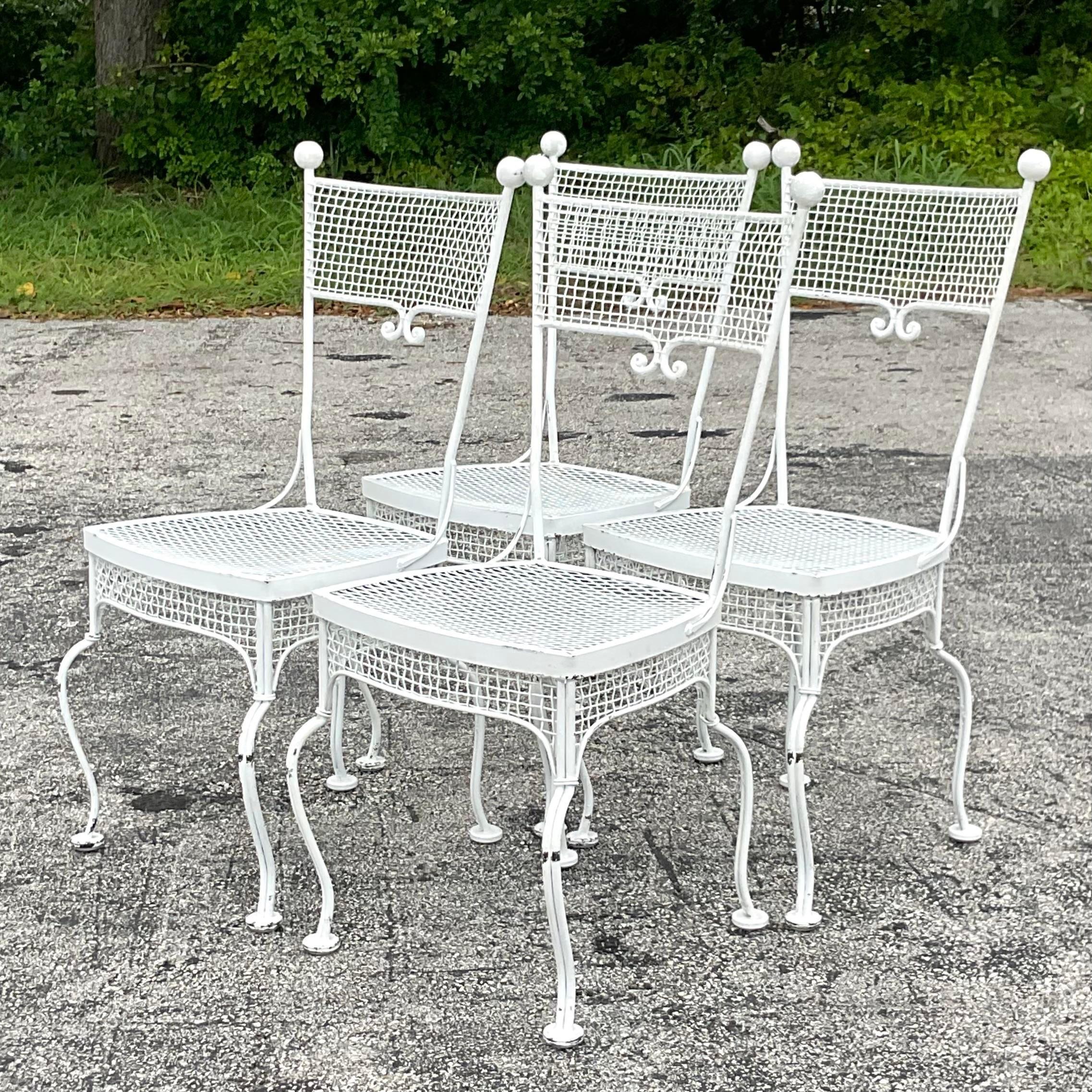 An incredible set of four vintage Coastal outdoor dining chairs. Done in the manner of Russell Woodard with his iconic metal mesh. Acquired from a Palm Beach estate.