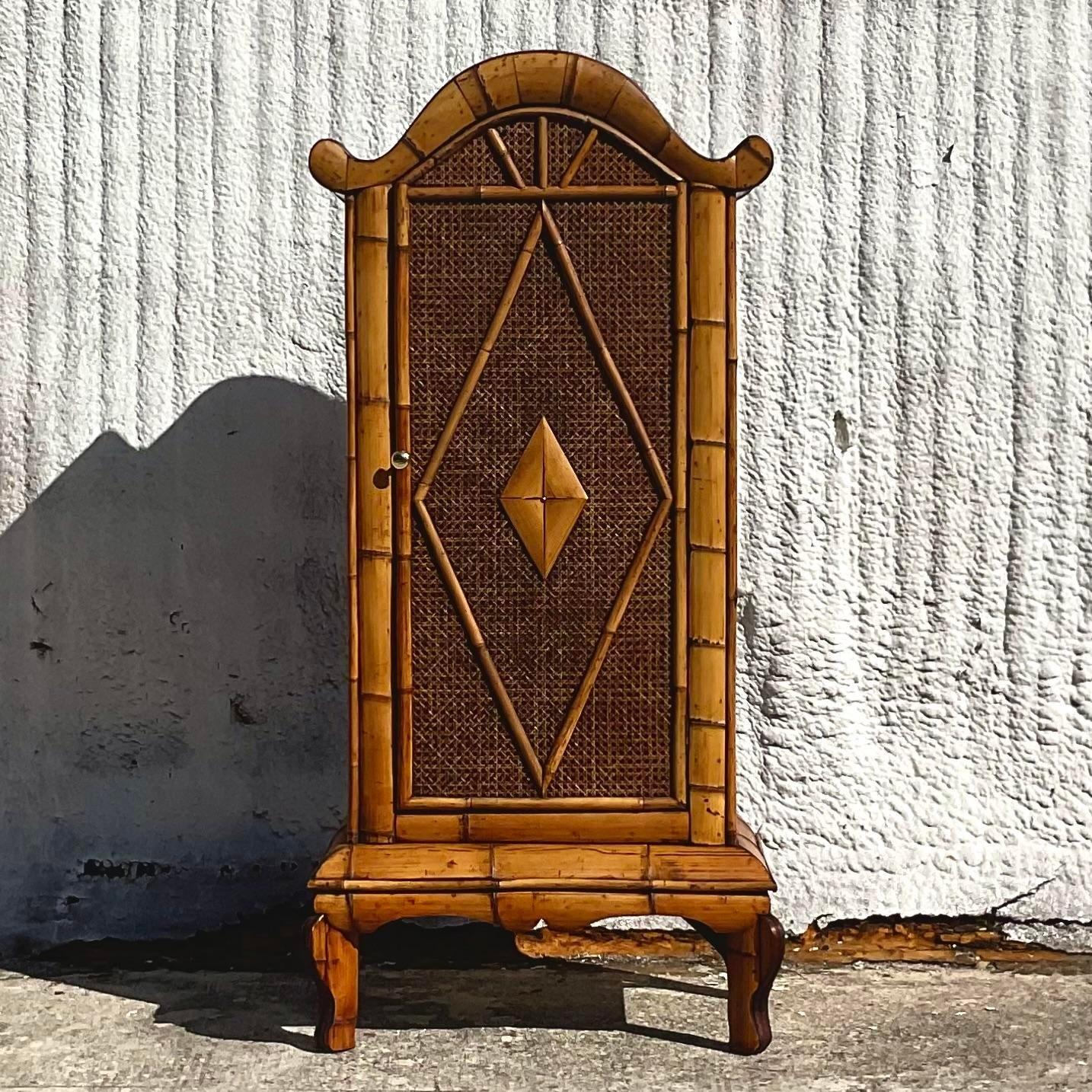 A fabulous vintage Coastal Storage cabinet. A chic arched design with a stylish diamond motif. Trimmed in split bamboo. Lots of great storage inside. Acquired from a Palm Beach estate. 