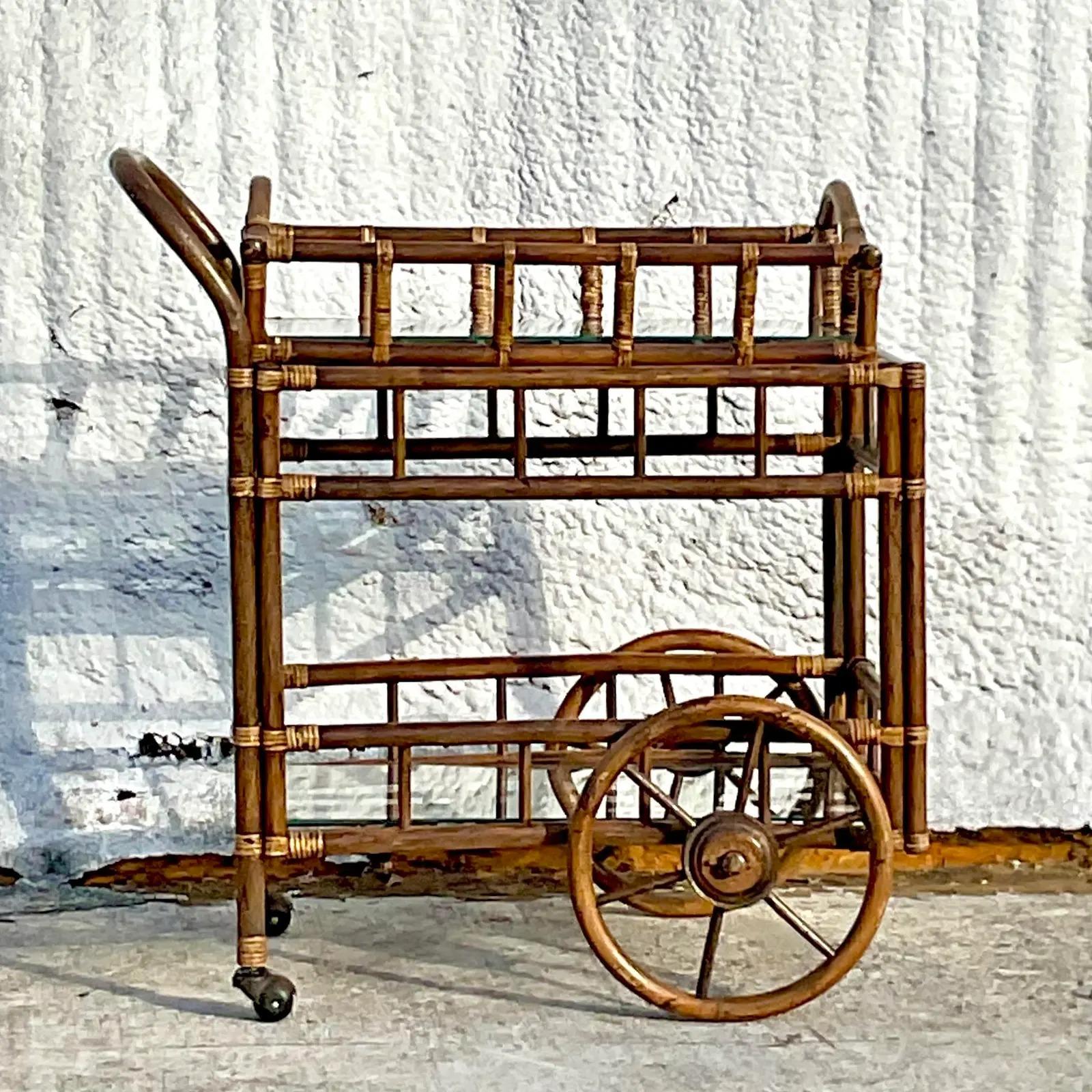 A fabulous vintage Coastal bar cart. A chic rattan frame with wheels and a removable butlers tray. Inset glass shelves. Acquired from a Palm Beach estate.