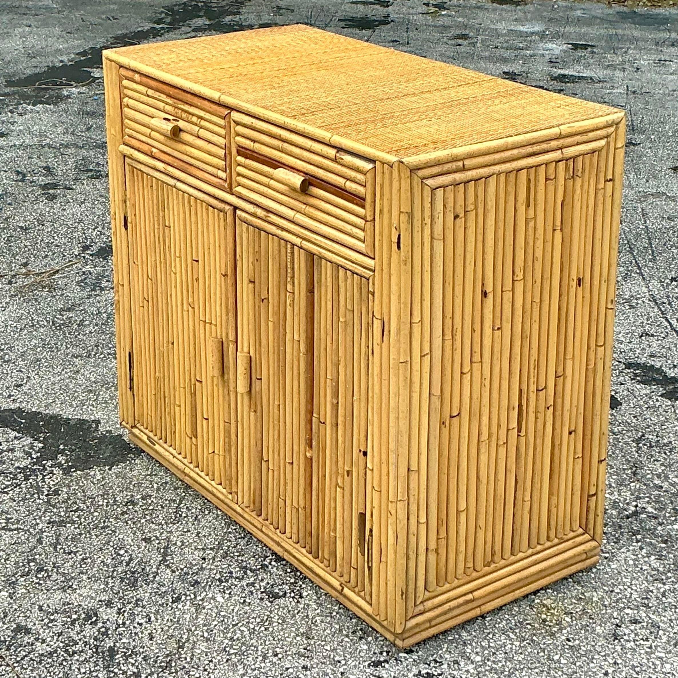 Bringen Sie mit dem Vintage Coastal Rattan Cabinet luftigen Küstencharme in Ihr Zuhause. Der aus natürlichem Rattan gefertigte Schrank verfügt über wunderschön geflochtene Paneele, die jedem Raum Struktur und Wärme verleihen. Sein luftiges Design