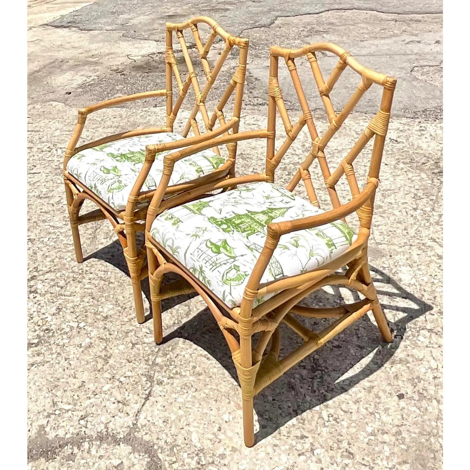 Fantastic pair of vintage Coastal rattan dining chairs. Iconic Chinese Chippendale design in the rattan. A beautiful green and white pagoda print seat. Acquired from a Naples estate.