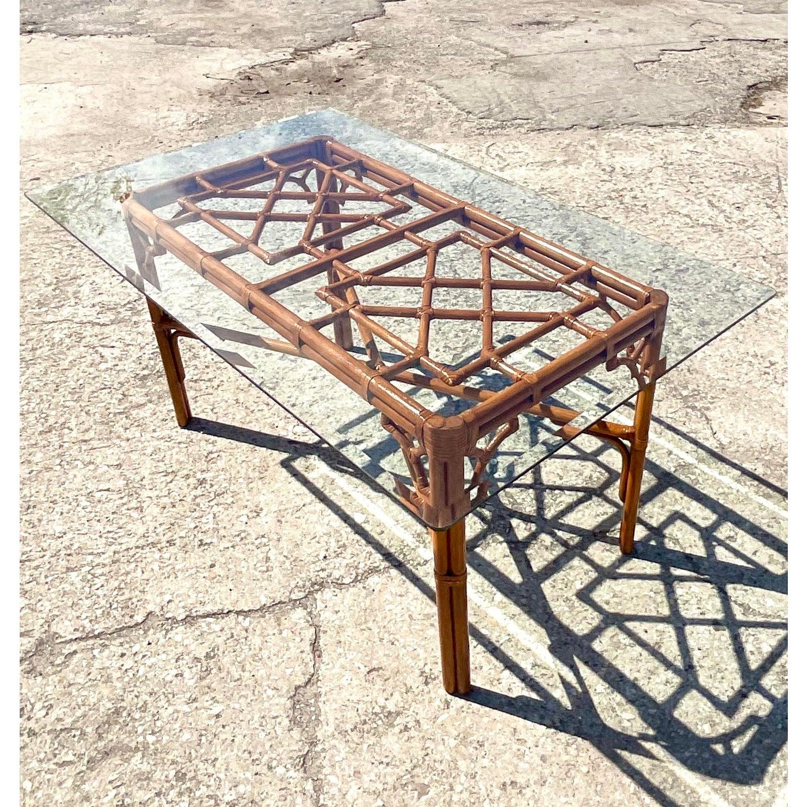 Fantastic vintage Coastal dining table. A chic dark rattan frame with a coveted Chinese Chippendale design. Glass top rests on the frame. Acquired from a Palm Beach estate.