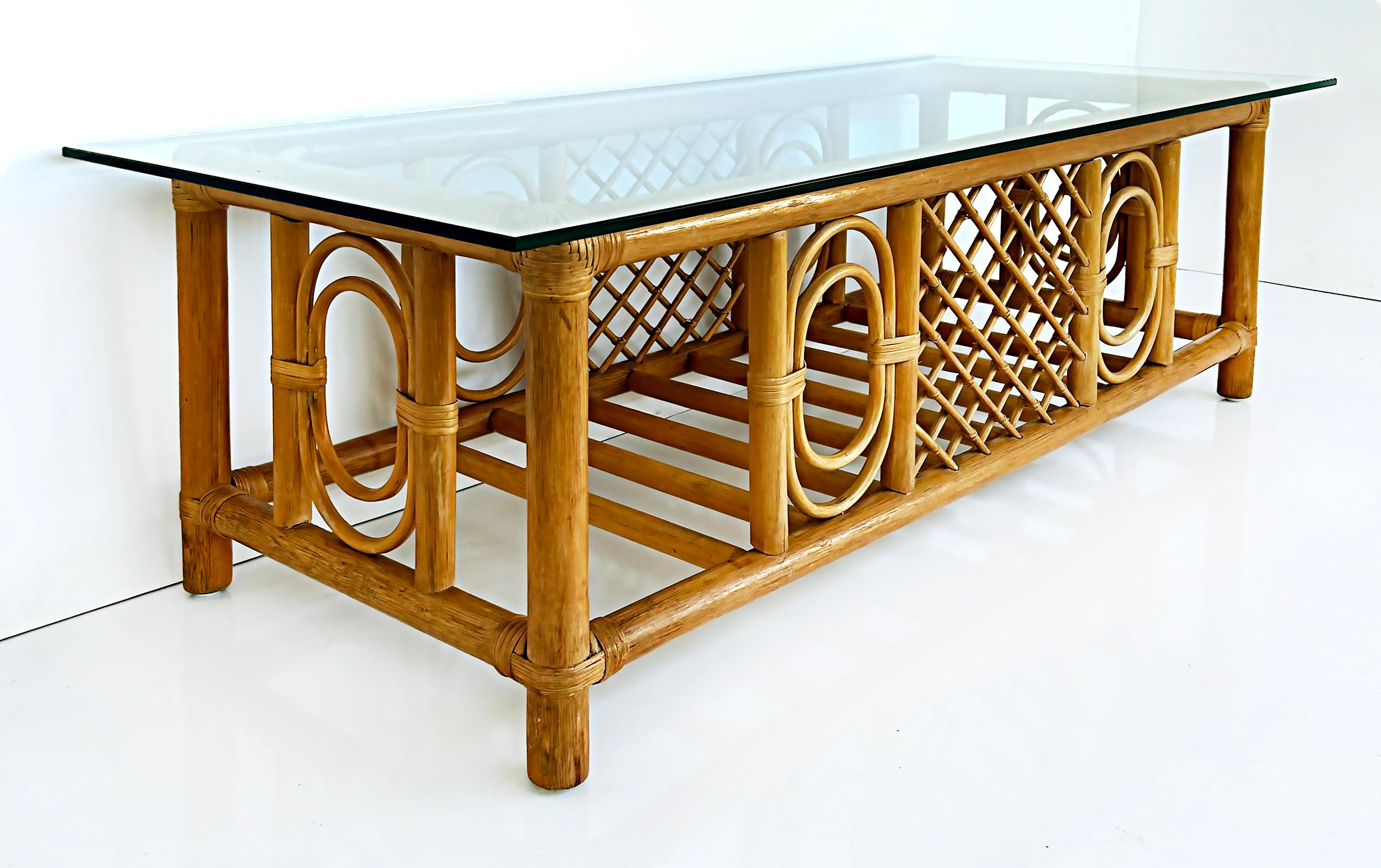 Vintage coastal rattan coffee cocktail table with glass top.

Offered for sale is a coastal rattan coffee cocktail table with a thick glass top. The table has a rectangular frame with decorative bent and crossed rattan details. The corners and