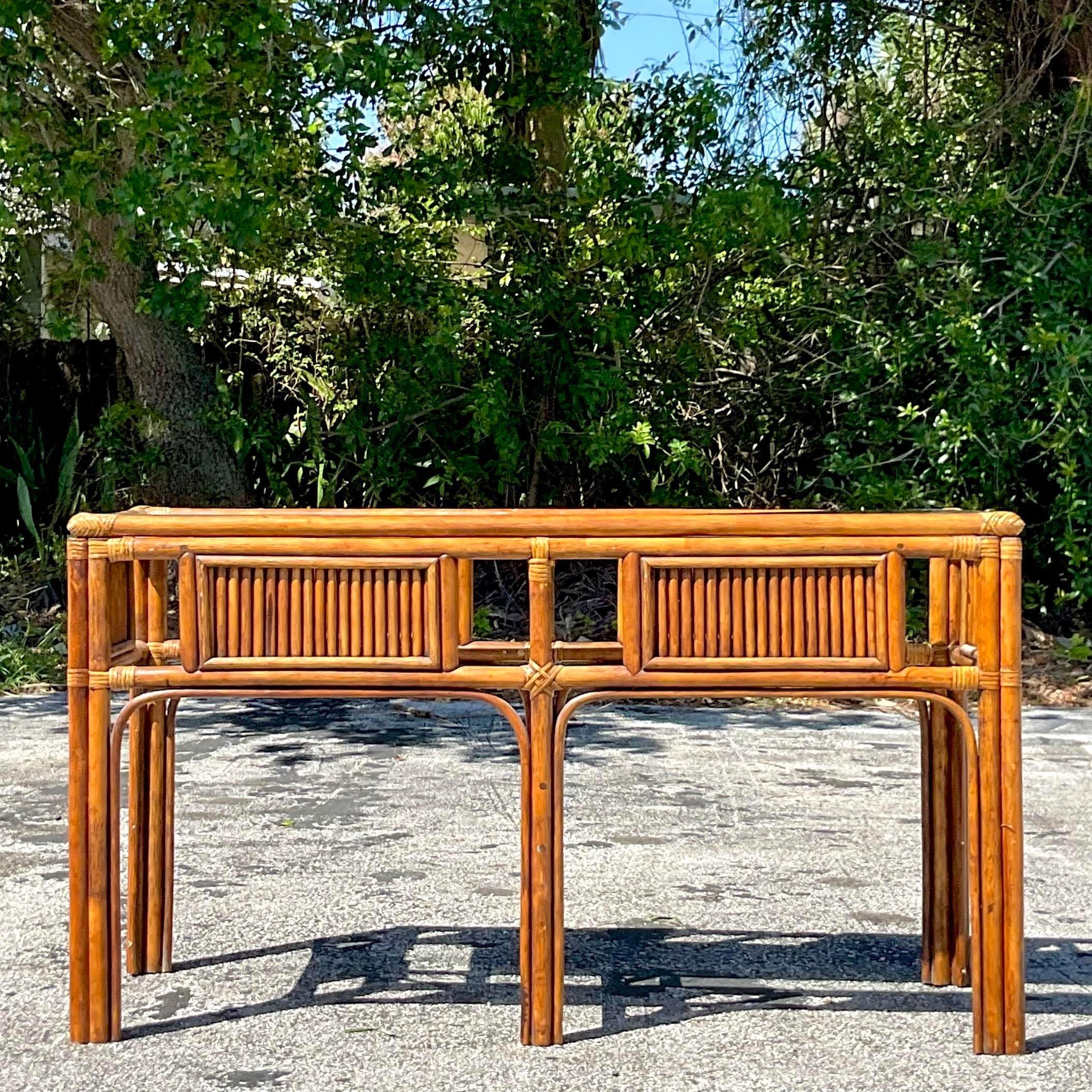 Bring coastal elegance into your home with the Vintage Coastal Rattan Console Table with inset glass top. Crafted with meticulous attention to detail, this table embodies classic American coastal style. The rattan construction adds a touch of