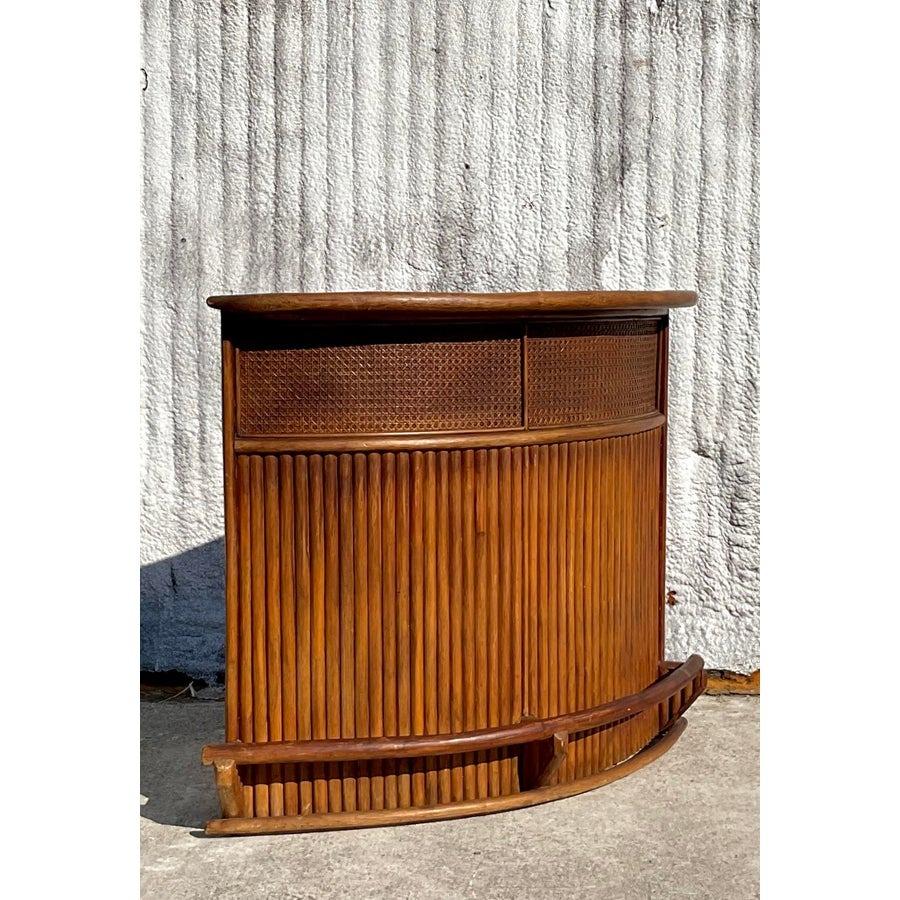 Apportez une touche d'élégance tropicale à votre intérieur avec ce bar sec incurvé vintage en rotin côtier. Avec sa silhouette joliment incurvée, ses panneaux en rotin tressé et ses tons naturels chauds, cette pièce respire le charme et la